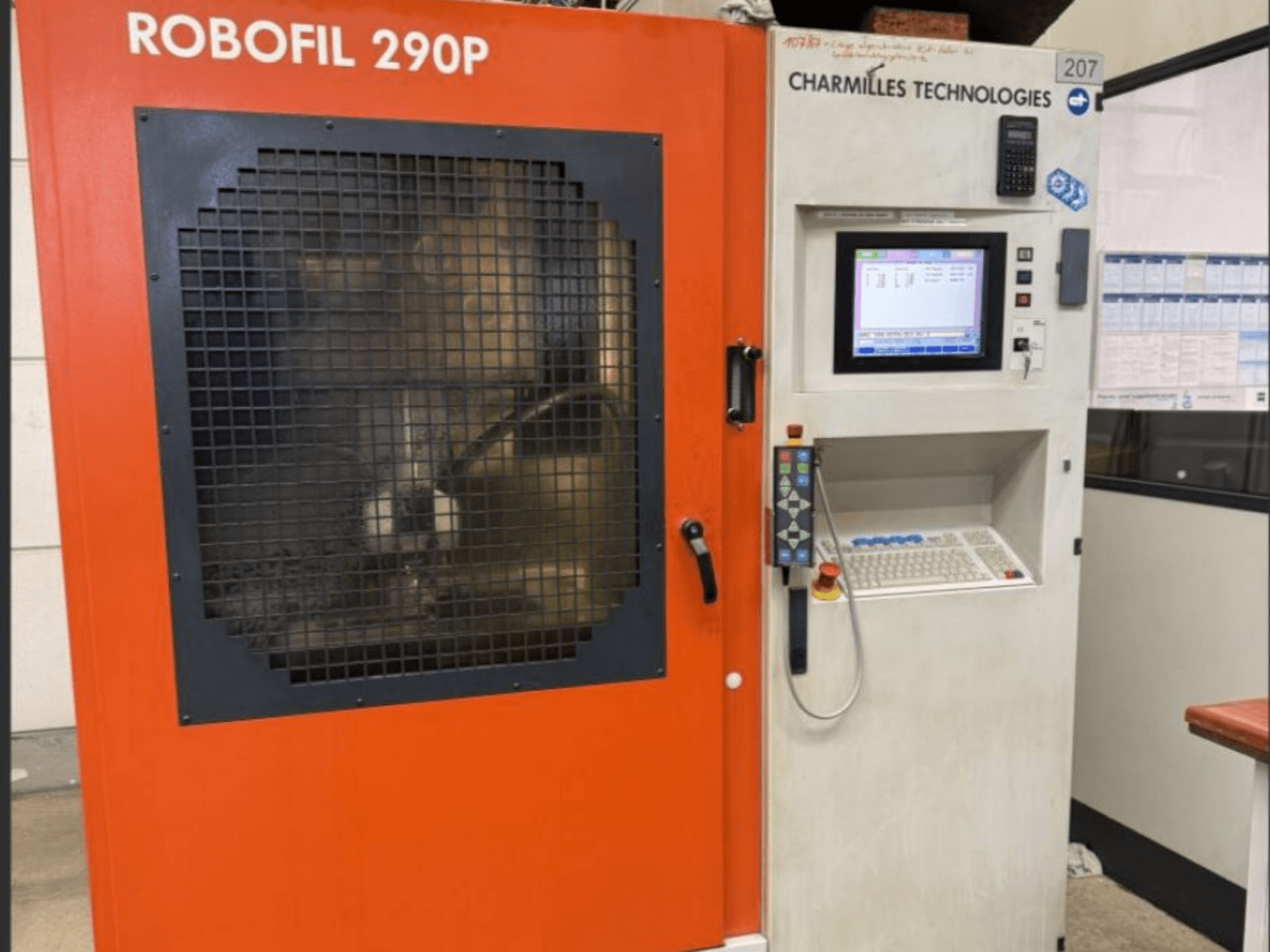 CHARMILLES TECHNOLOGIES Robofil 290P stiepļu EDM mašīnas priekšējais skats ar vadības paneli un režģa aizsargāto darba zonu.