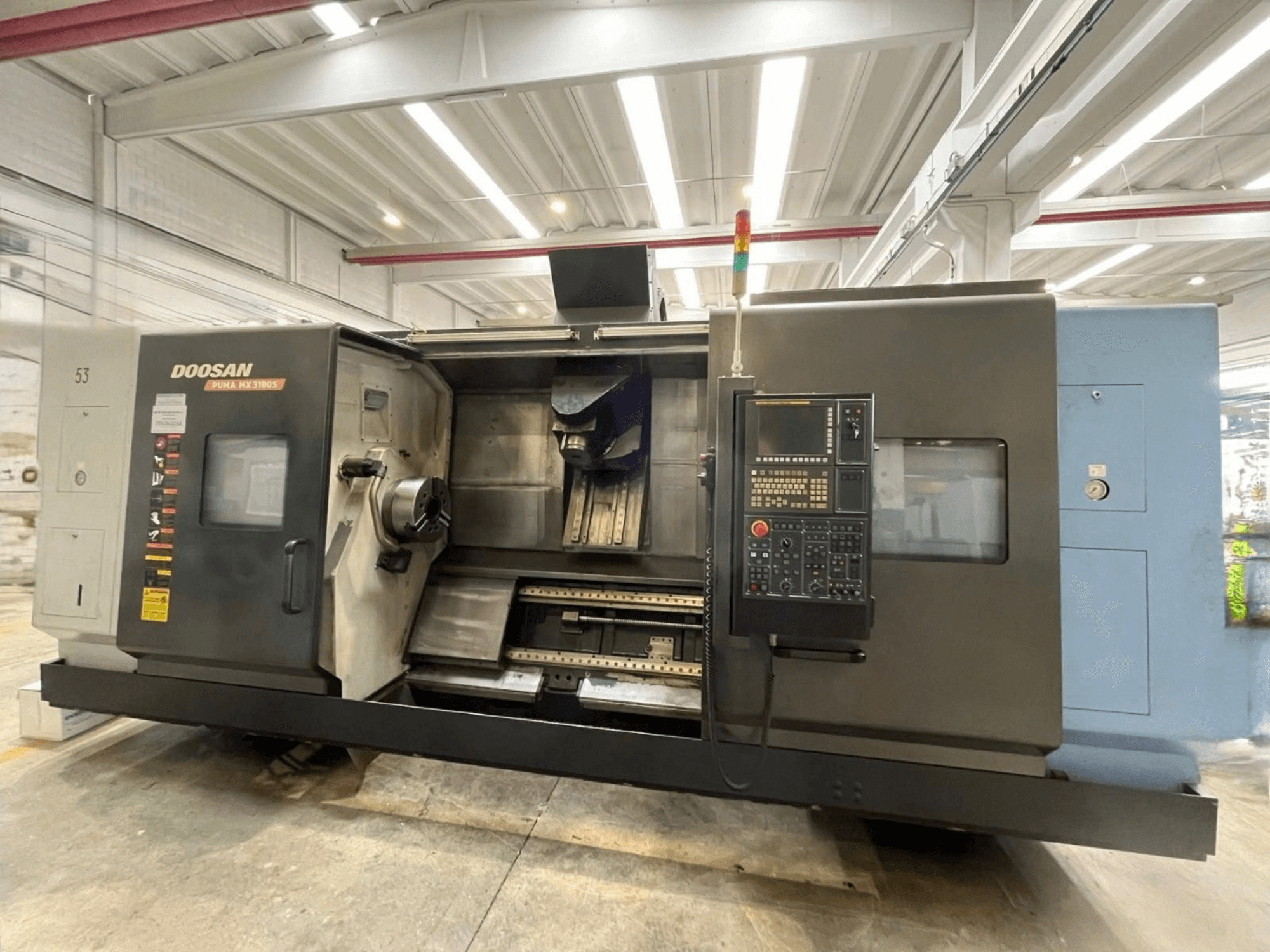 DOOSAN PUMA MX3100 horizontālās virpošanas mašīnas skats no priekšpuses ar vadības paneli un redzamu vārpstas un instrumentu turētāja zonu.