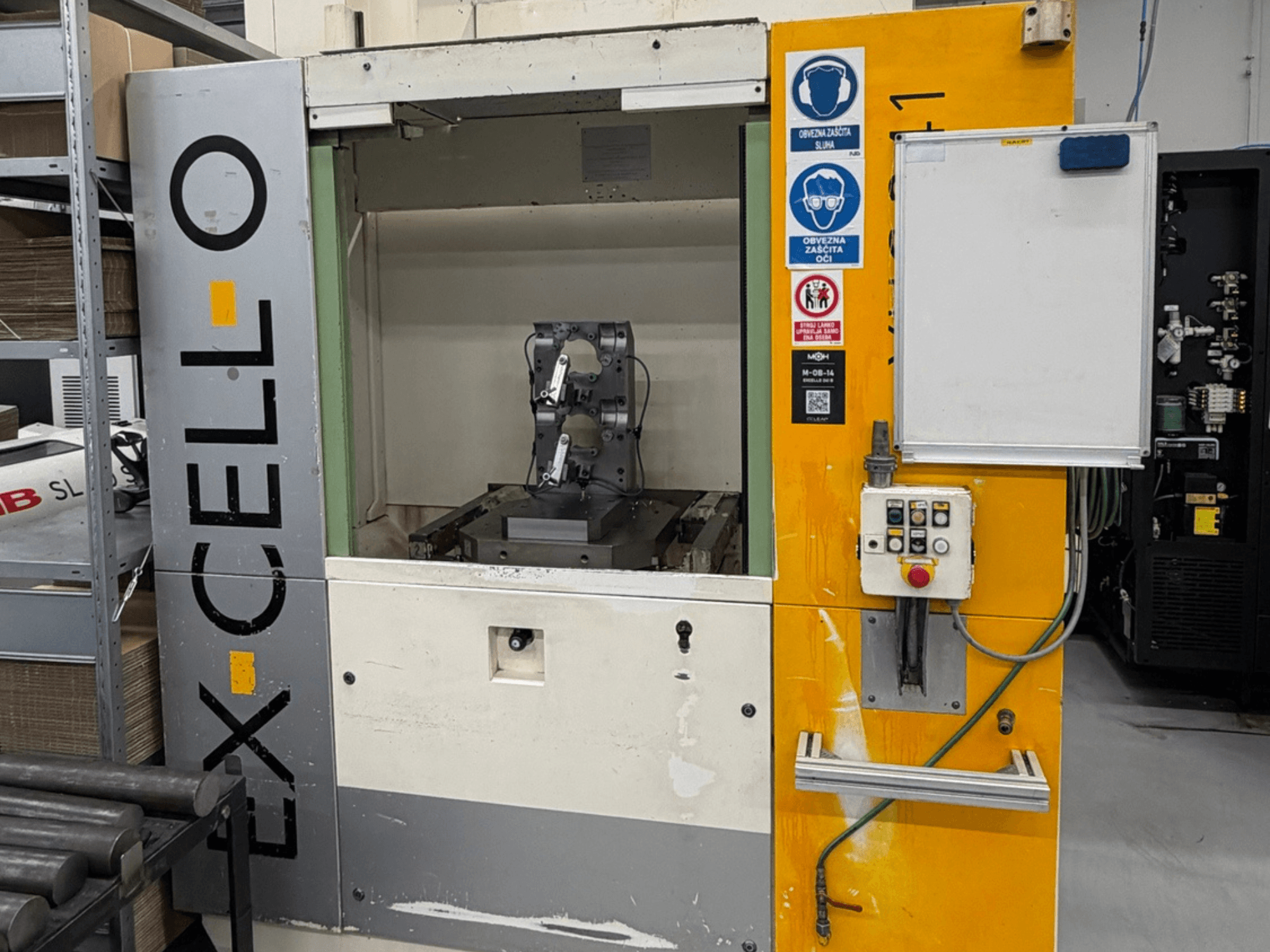 EXCELLO XHC 241 M/3 horizontālā apstrādes centra priekšējais skats ar redzamo vadības paneli un mašīnas iekšpusi.