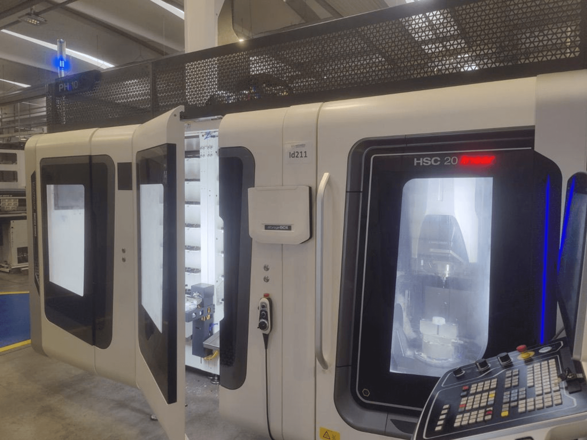 DMG MORI HSC 20 vertikālais apstrādes centrs, skats no priekšpuses, ar atvērtām durvīm, kurās redzams apstrādes iekšpuse un vadības panelis.