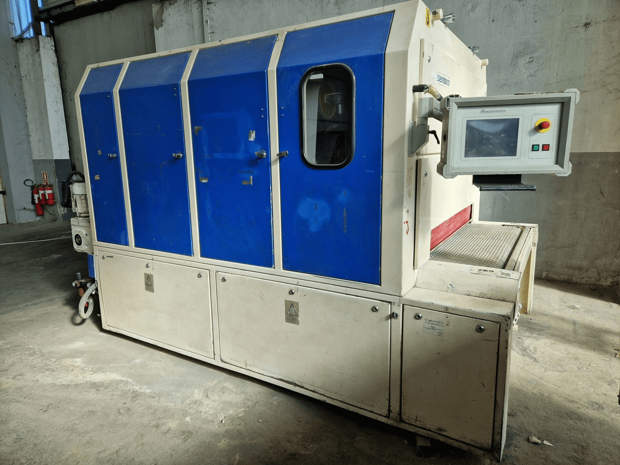 Zīmola "Sedecom" rūpnieciskā mašīna, skats no sāniem; ar ziliem paneļiem, vadības ekrānu un teksturētu virsmu produktu apstrādei.