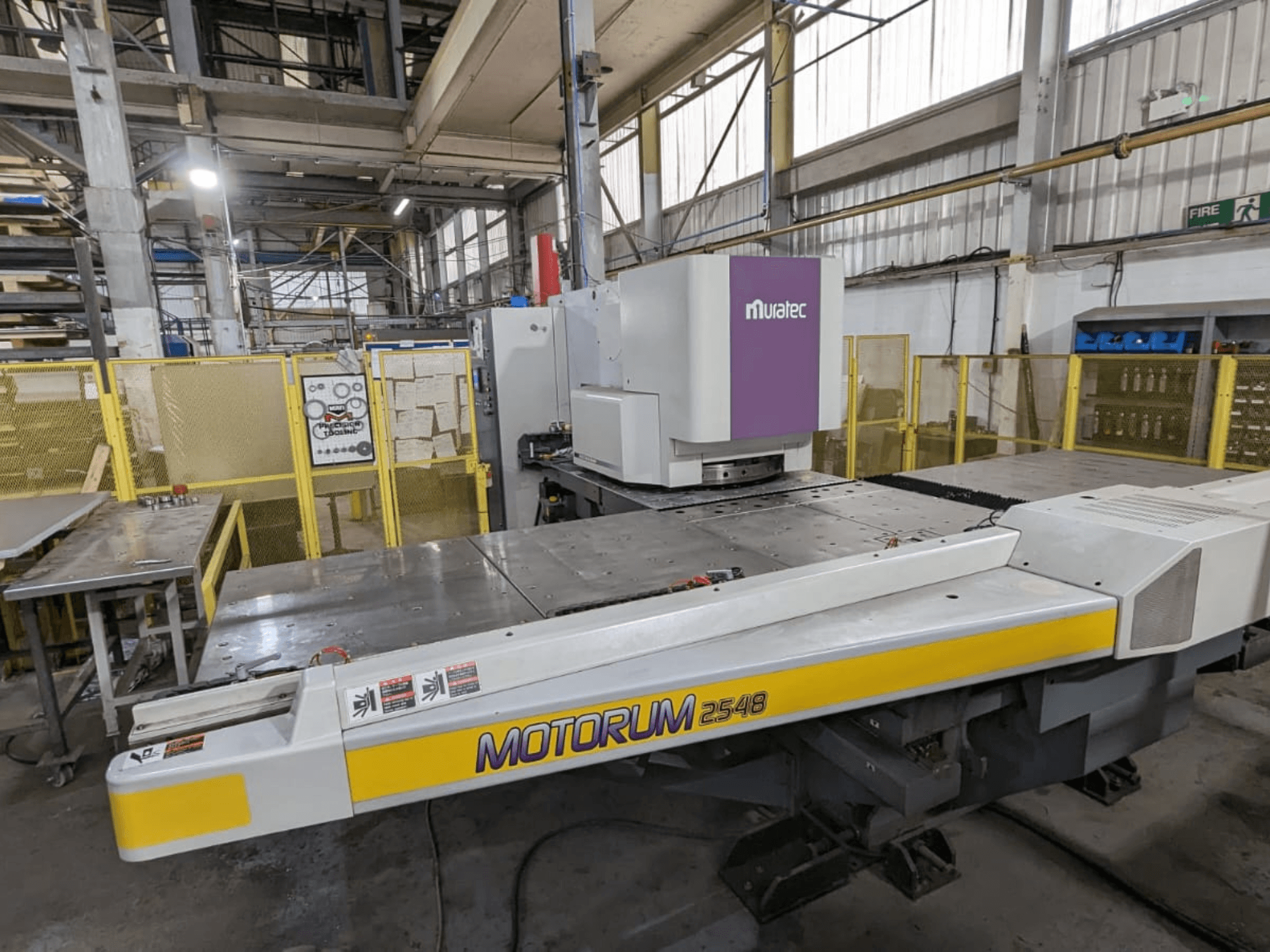Muratec MOTORUM 2548 CNC perforācijas preses priekšskats, kurā redzams vadības panelis un darba galds rūpnīcas uzstādījumos.