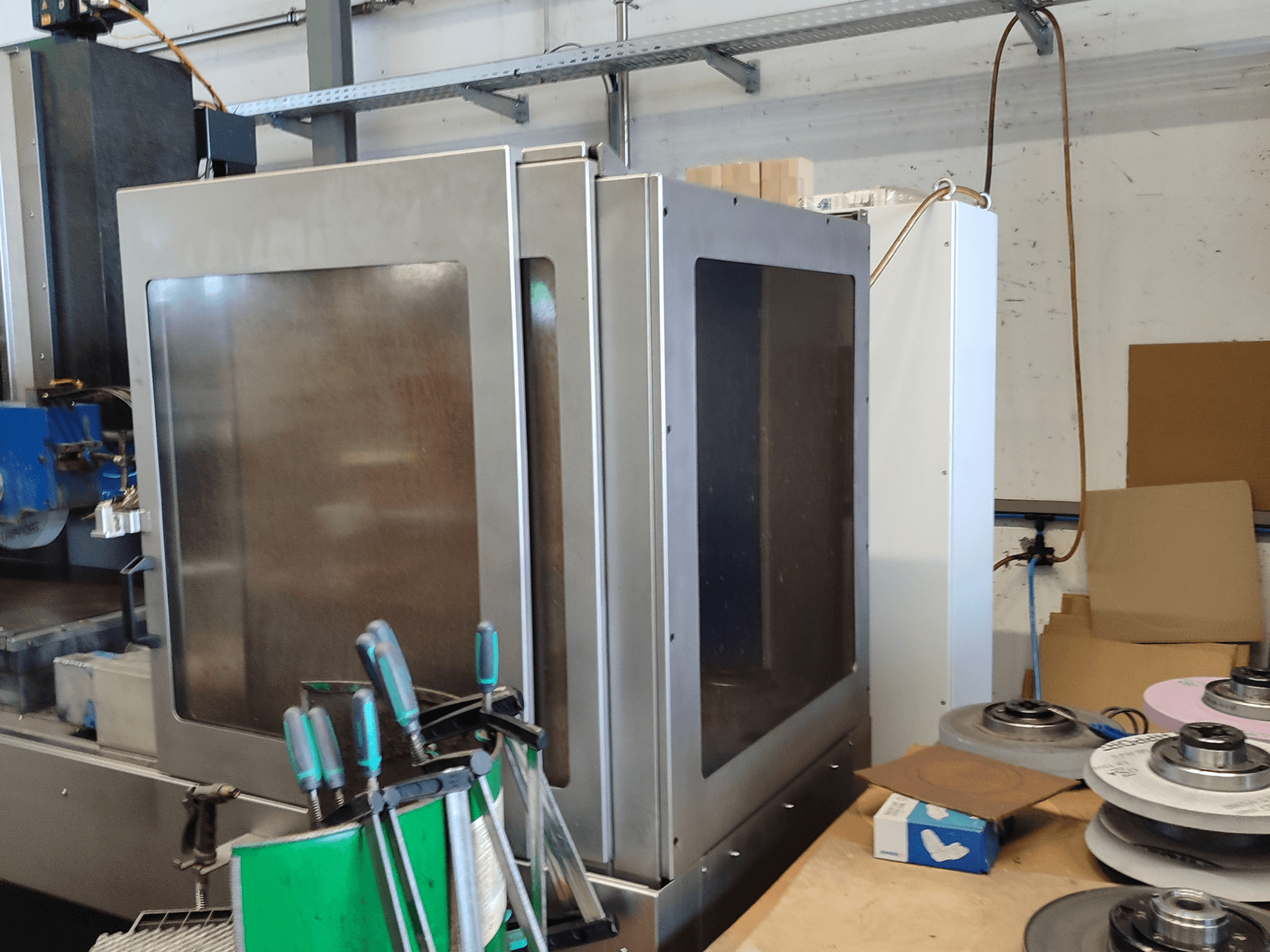 HEINZ STÖCKEL FD 1560 NC-T virsmas slīpmašīna, sānu skats, kurā redzams metāla korpuss un slīpēšanas komponenti darbnīcā.