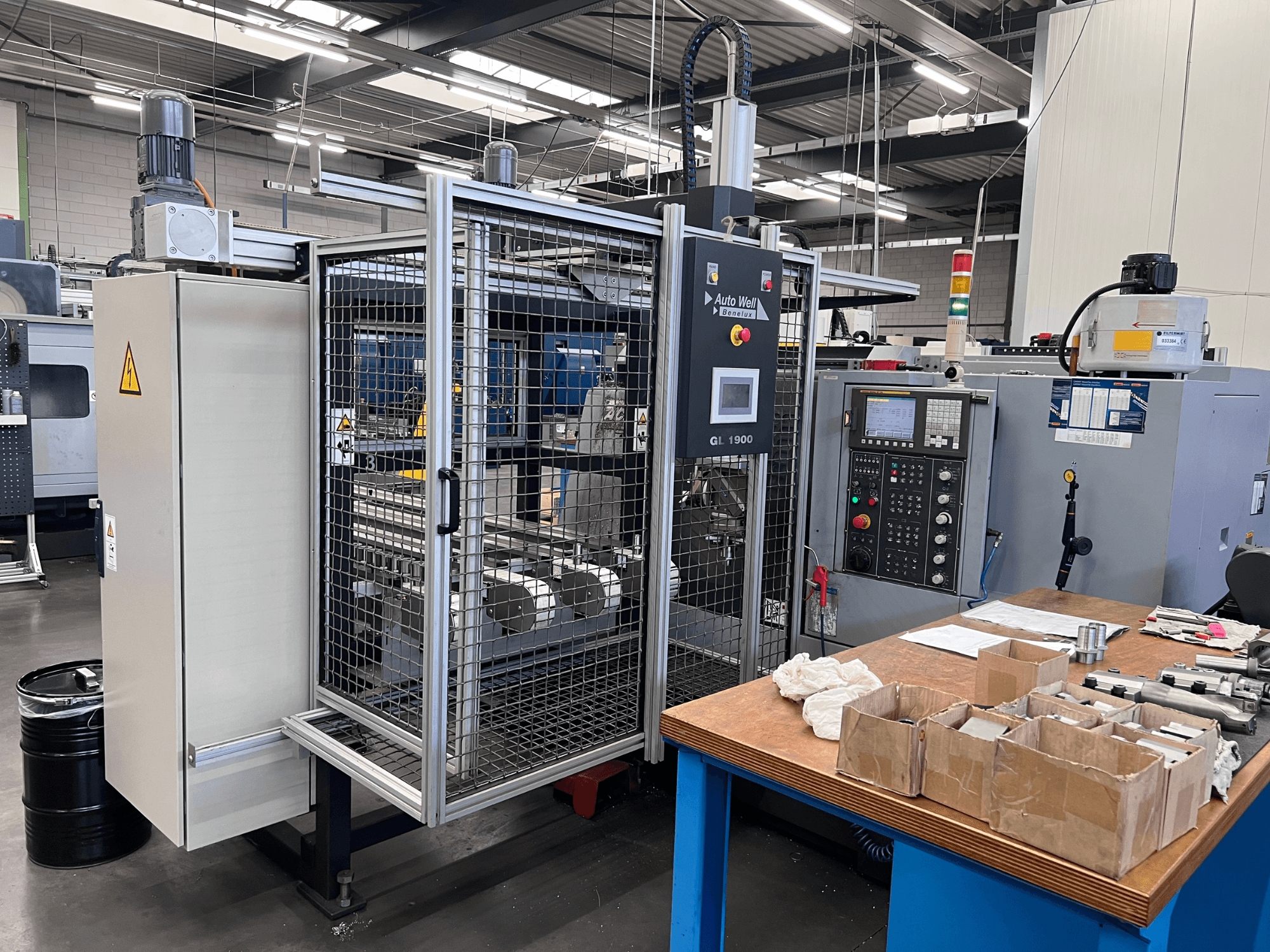 Auto Weld GL 1900 iekārtas priekšējais skats ar vadības paneli, drošības nodalījumu un apkārtējiem instrumentiem uz darba galda.