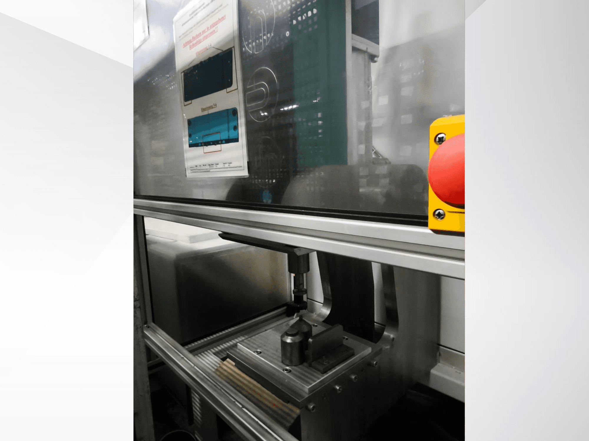 EMS Automation Buchsenpresse darbgalda priekšējais skats, kurā redzams presēšanas mehānisms un drošības poga.