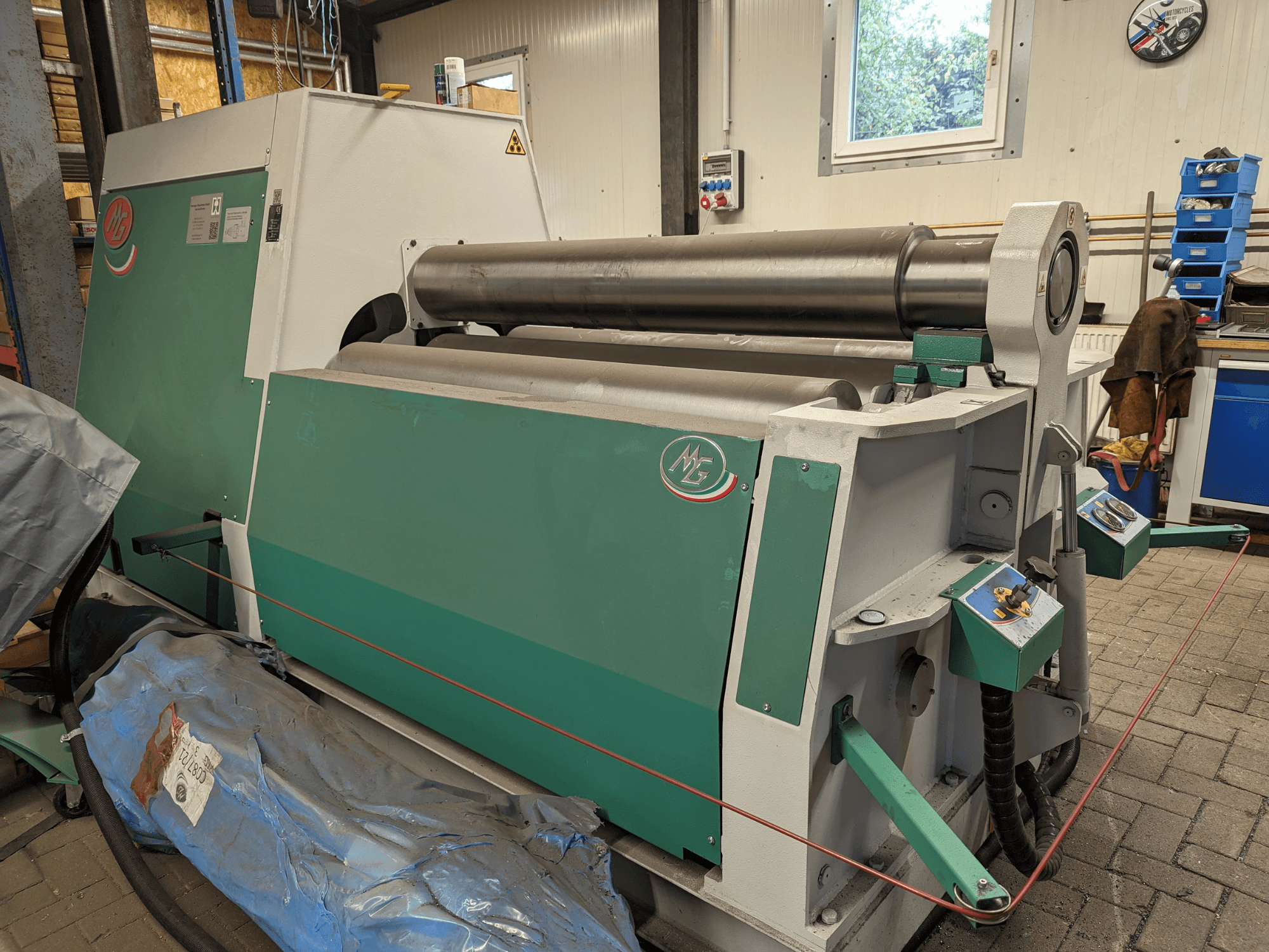 MG ruļļu liekšanas mašīnas MG4R1520C modelis zaļā un pelēkā krāsā, sānu skats, kurā redzami trīs metāla ruļļi un vadības paneļi.