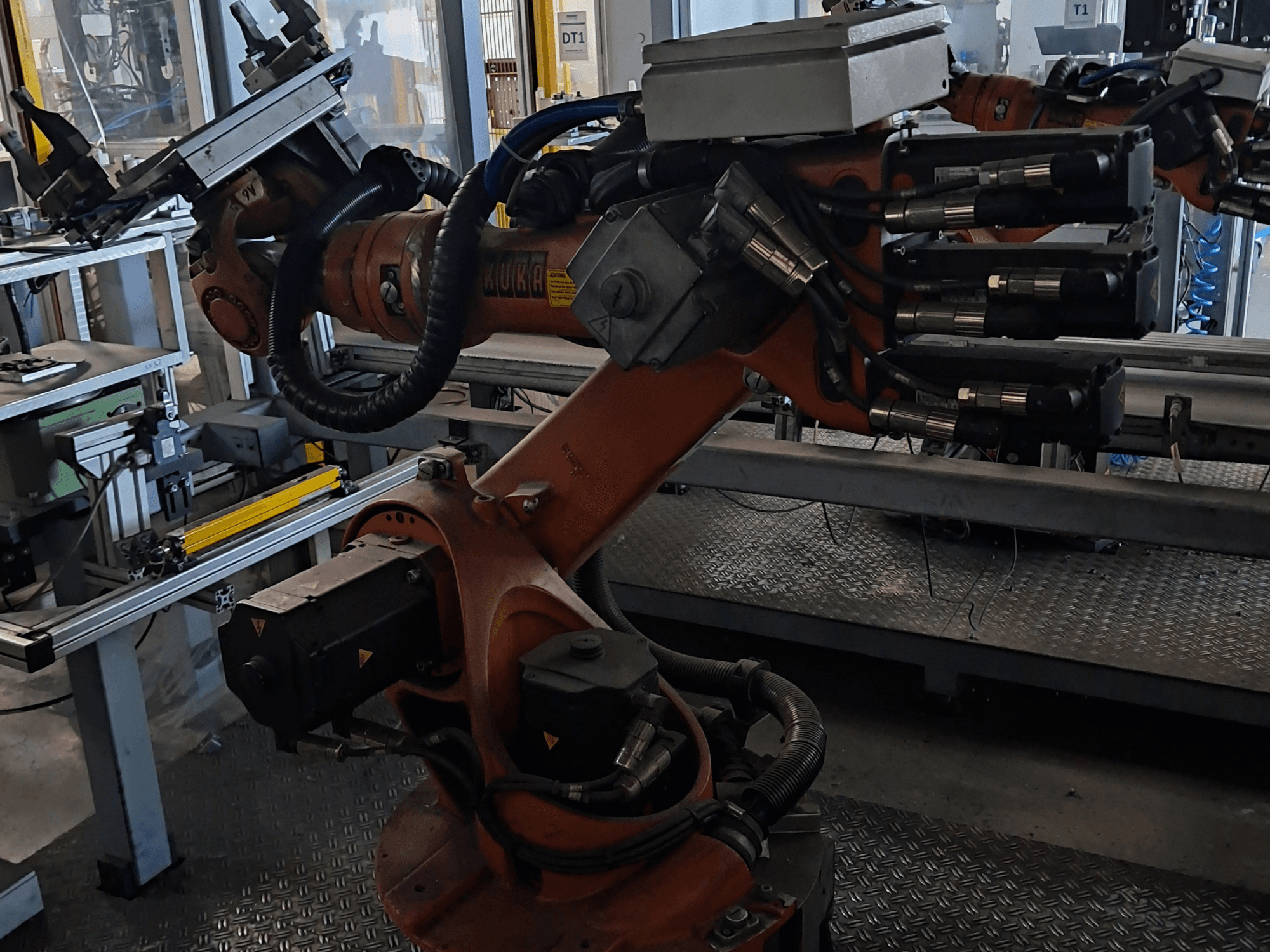 KUKA KR 16-2 robota roka ar KRC 4 vadības bloku, skats no sāniem, kurā redzami šarnīrveida savienojumi un hidrauliskie savienojumi.