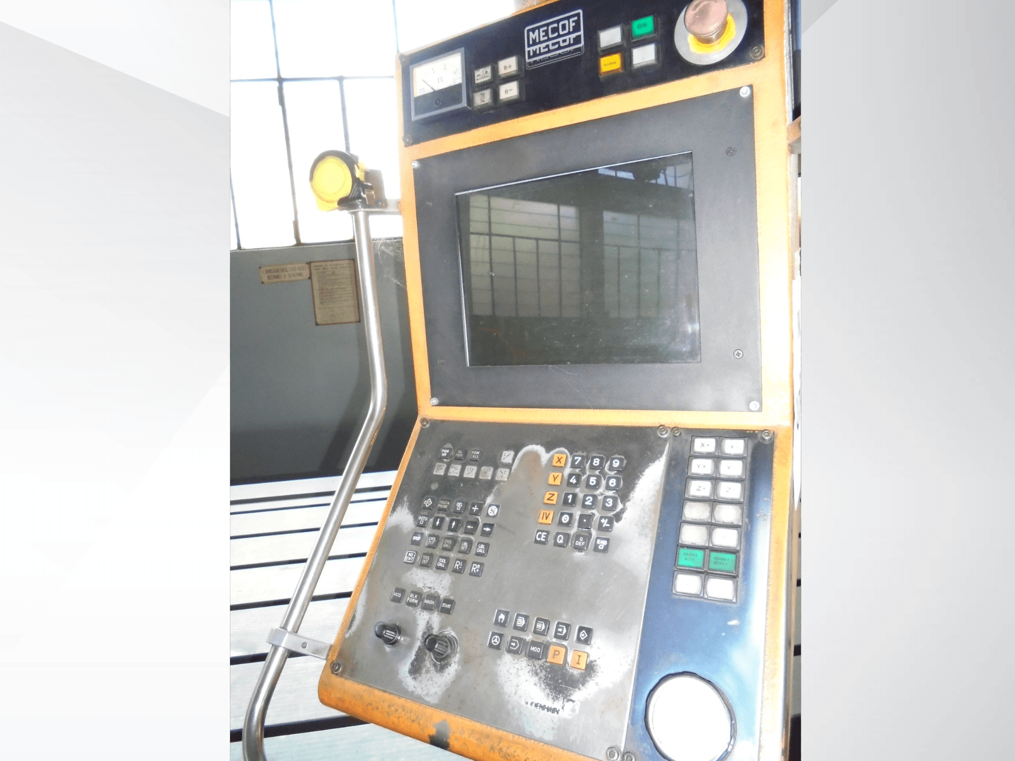 Mecof vadības panelis ar digitālo displeju, pogām un slēdžiem; priekšējais skats, kurā redzams vadības ierīču nolietojums.