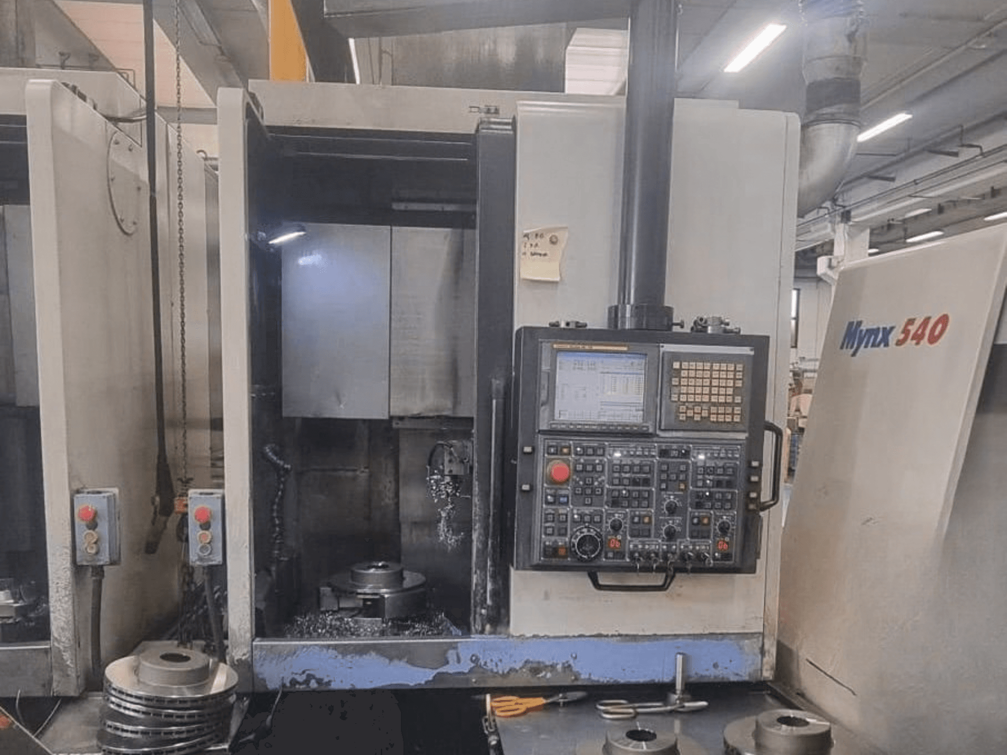 DOOSAN PUMA V400-2SP vertikālās virpas skats no priekšpuses, kurā redzams vadības panelis un detaļas novietojums iekārtas iekšienē.