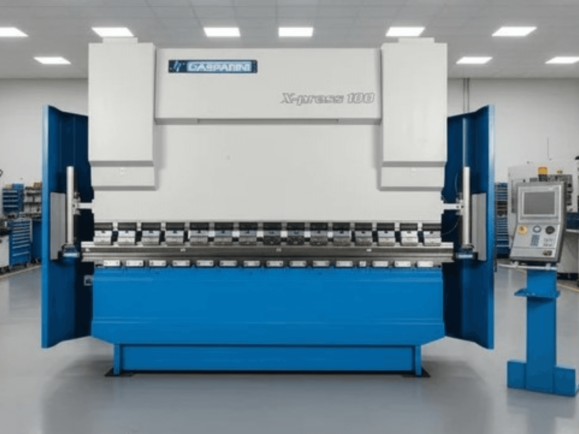 Hidrauliskā prese „GASPARINI X-Press 100“, skats no priekšpuses, ar zilu korpusu un vadības paneli labajā pusē.