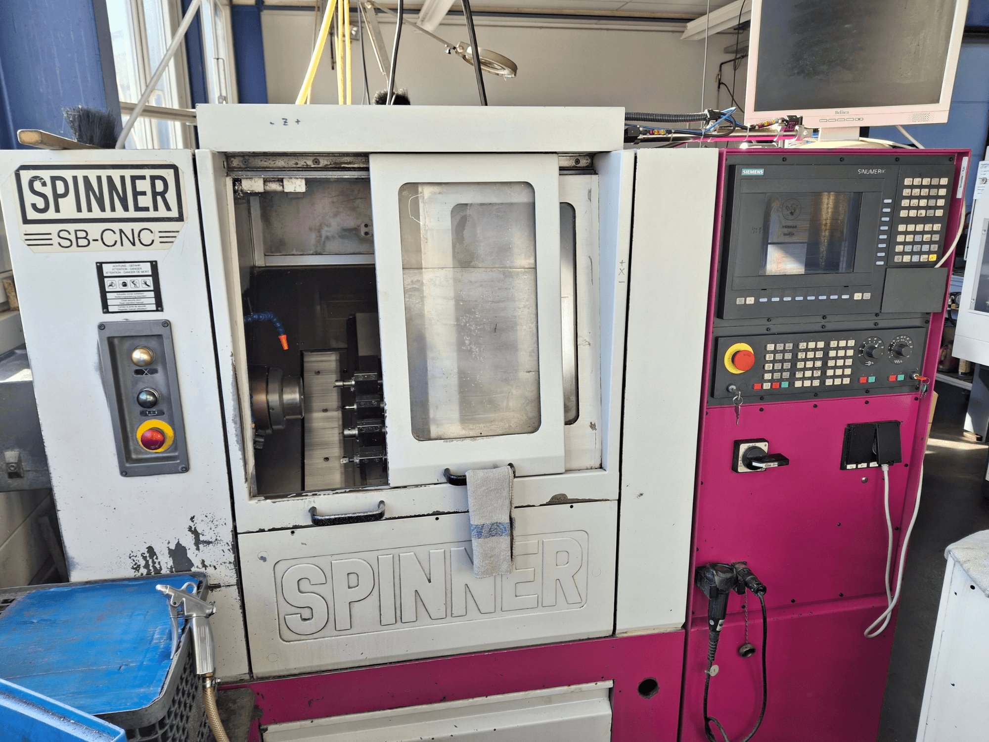 Horizontālās virpošanas darbgalds SPINNER SB-CNC, priekšējais skats, kurā redzams vadības panelis, instrumentu turētājs un darbības indikatori.