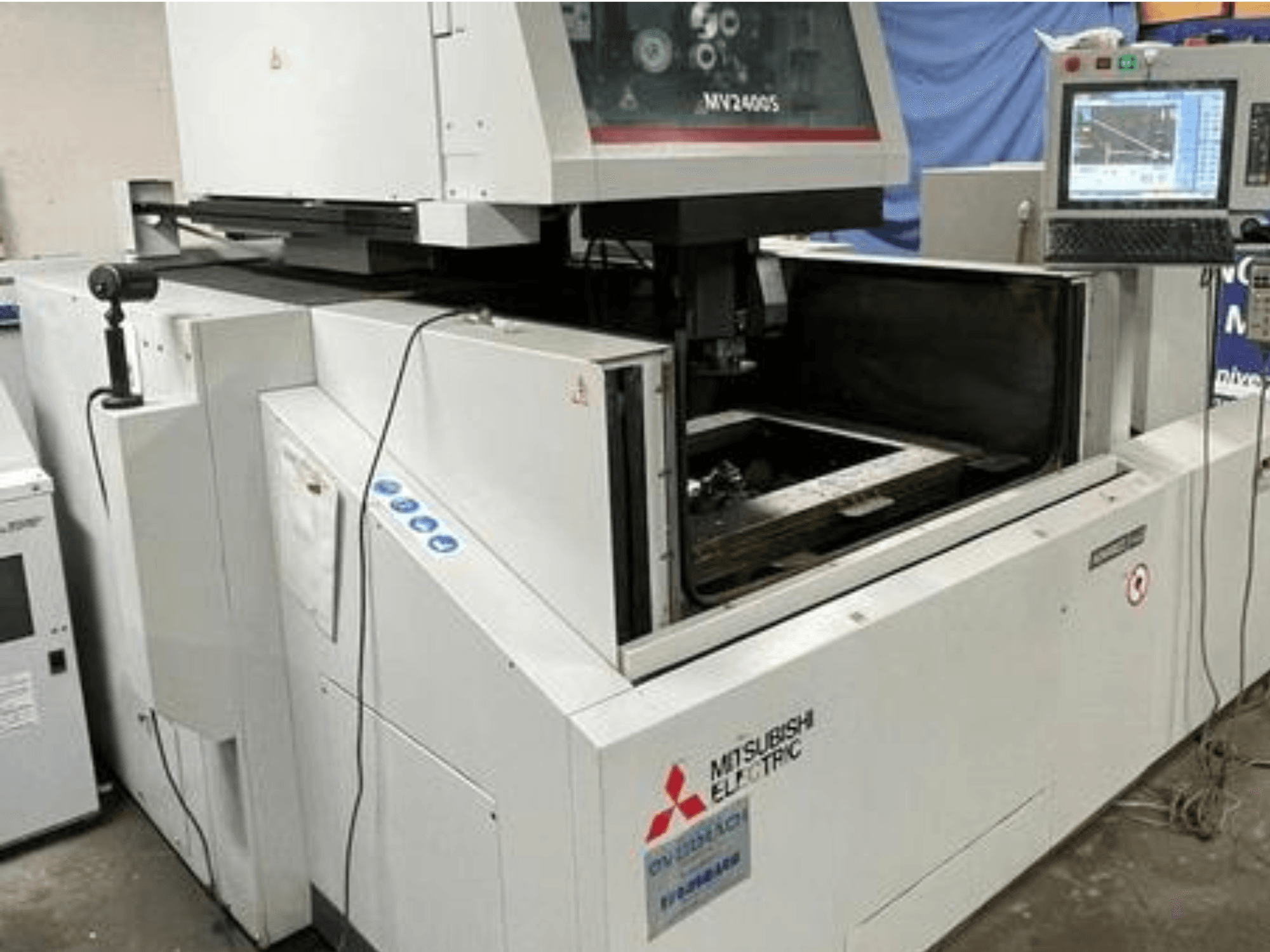 Mitsubishi Electric MV2400S stiepļu griešanas EDM mašīna, skats no priekšpuses, redzams vadības panelis un atvērta darba zona.