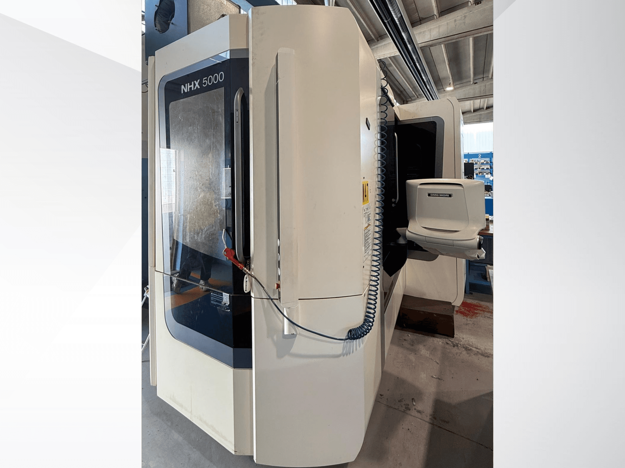 DMG MORI NHX 5000 horizontālā virpošanas mašīna, skats no priekšpuses, kurā redzams vadības panelis un vārpstas turētājs.