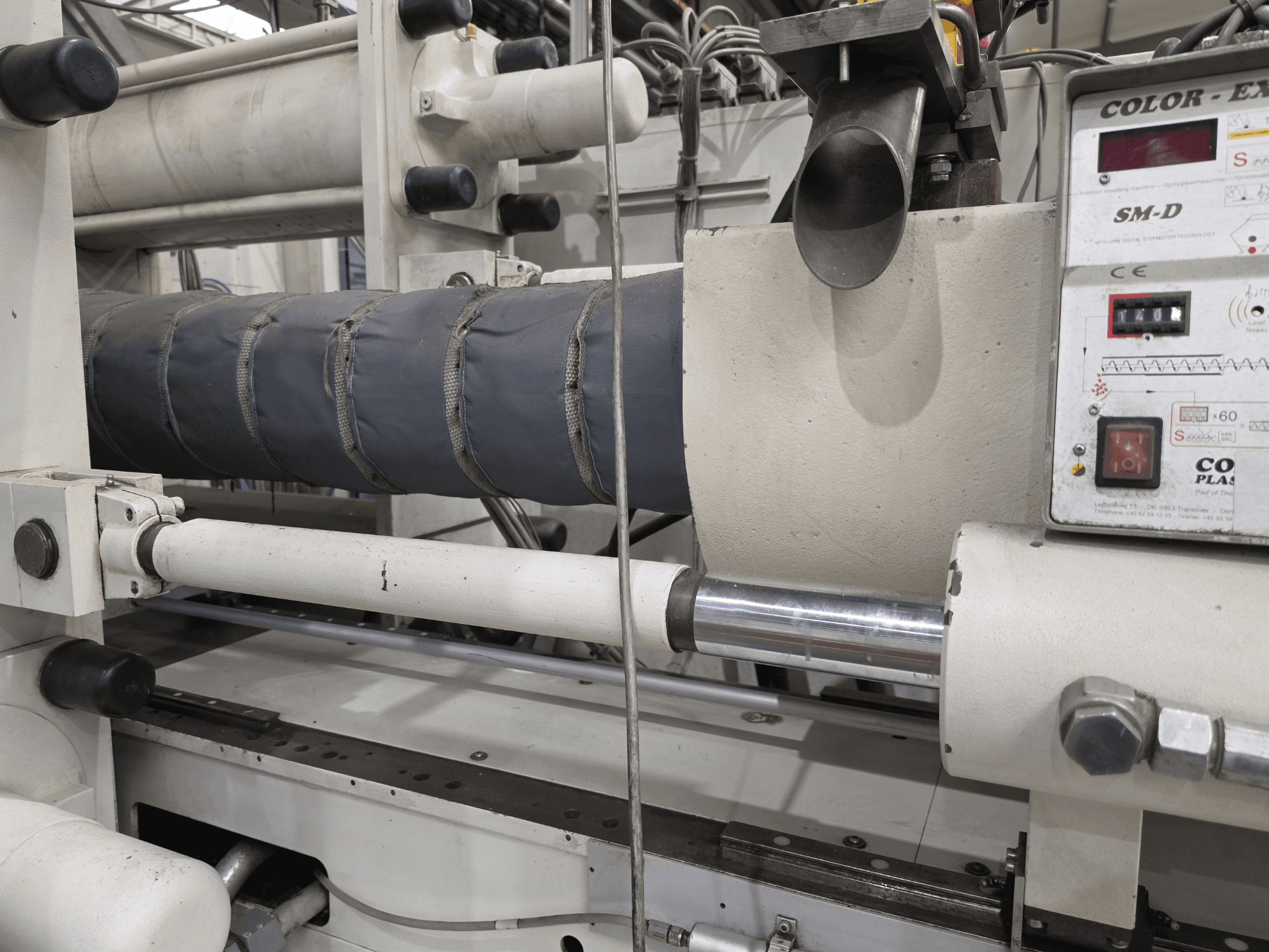 Krauss Maffei 350-3000 CX hidrauliskā iesmidzināšanas iekārta, sānu skats, kurā redzams temperatūras kontroles panelis un sildelementi.