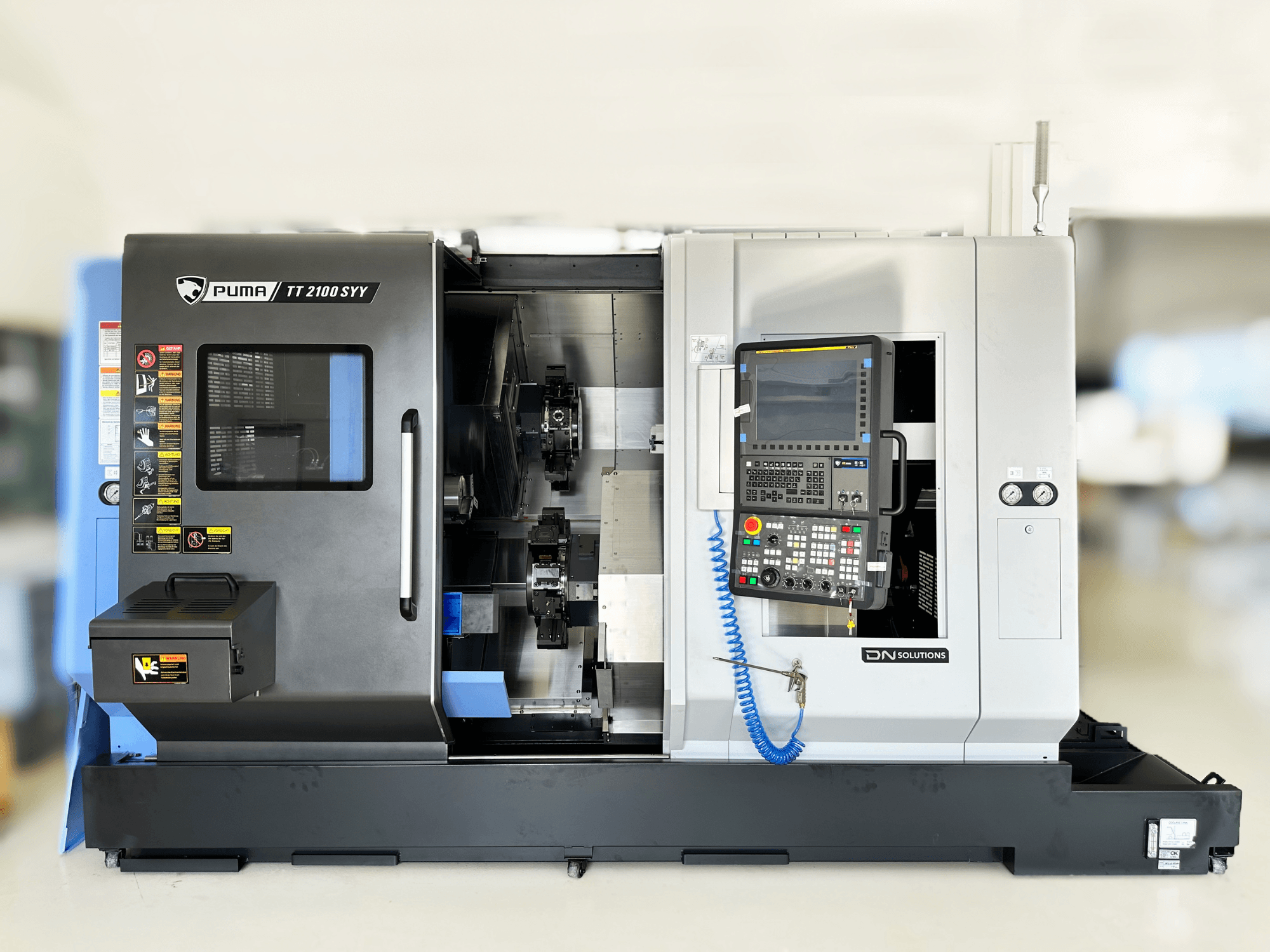 Virpošanas frēzēšanas centrs DN SOLUTIONS PUMA TT2100SYY priekšējais skats ar vadības paneli un redzamām iekšējām detaļām.