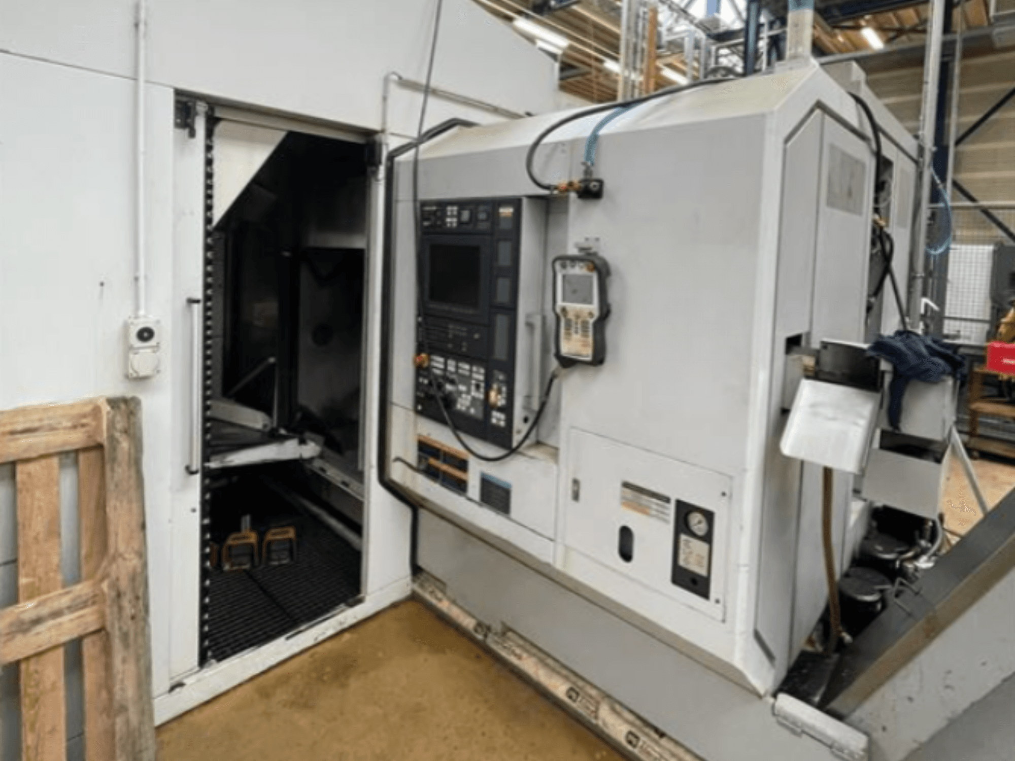 DMG Mori Seiki NZ2000T3Y2 horizontālās virpošanas iekārta, sānu skats, kurā redzams vadības panelis un iekārtas iekšpuse.