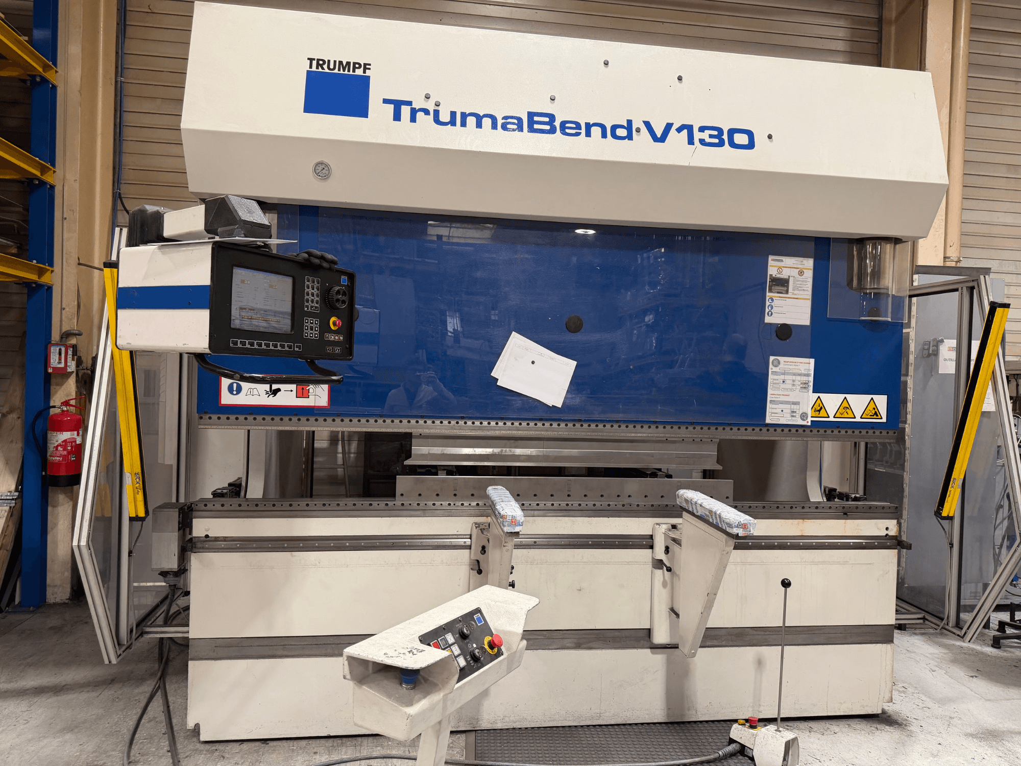TRUMPF TrumaBend V130 lieces preses iekārta rūpnīcas konfigurācijā ar vadības paneli un drošības funkcijām, skats no priekšpuses.