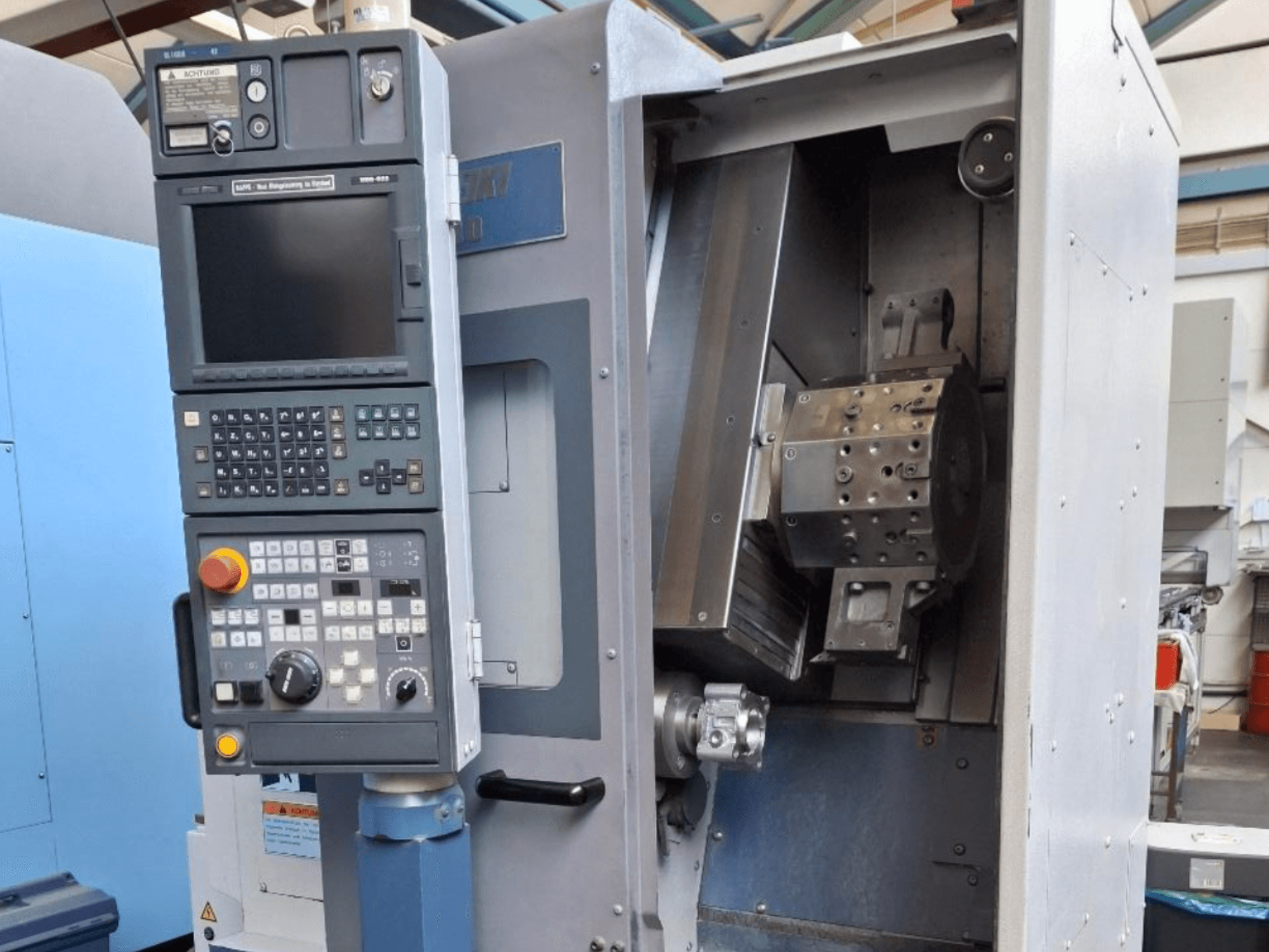 MORI SEIKI SL 1000 horizontālās virpošanas mašīnas priekšējais skats ar vadības paneli un detalizētu iekšējo mehānismu.