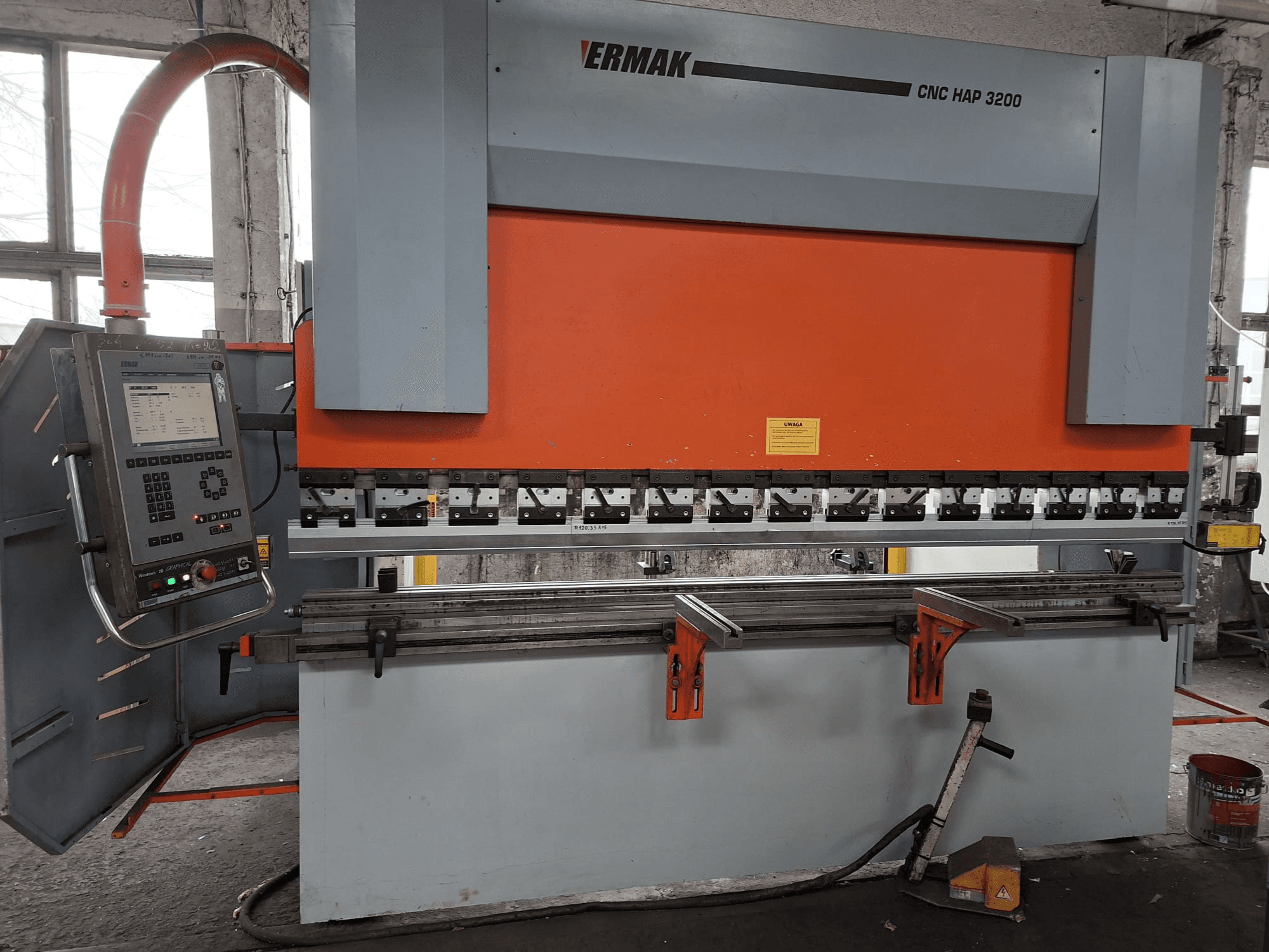 Ermak CNC HAP 3200 preses bremze, skats no priekšpuses, ar oranžu un pelēku korpusu, vadības paneli ar digitālo displeju un regulējamām skavām.
