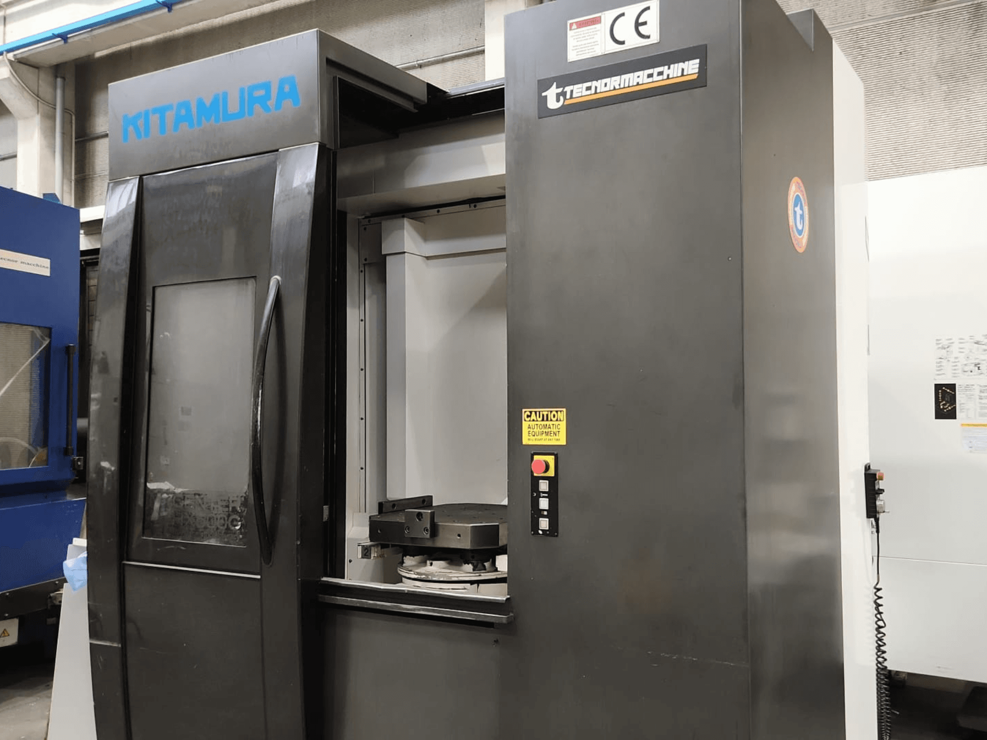 Kitamura Mycenter HX500iG horizontālais apstrādes centrs, skats no priekšpuses, kurā redzams vadības panelis un darba zona.