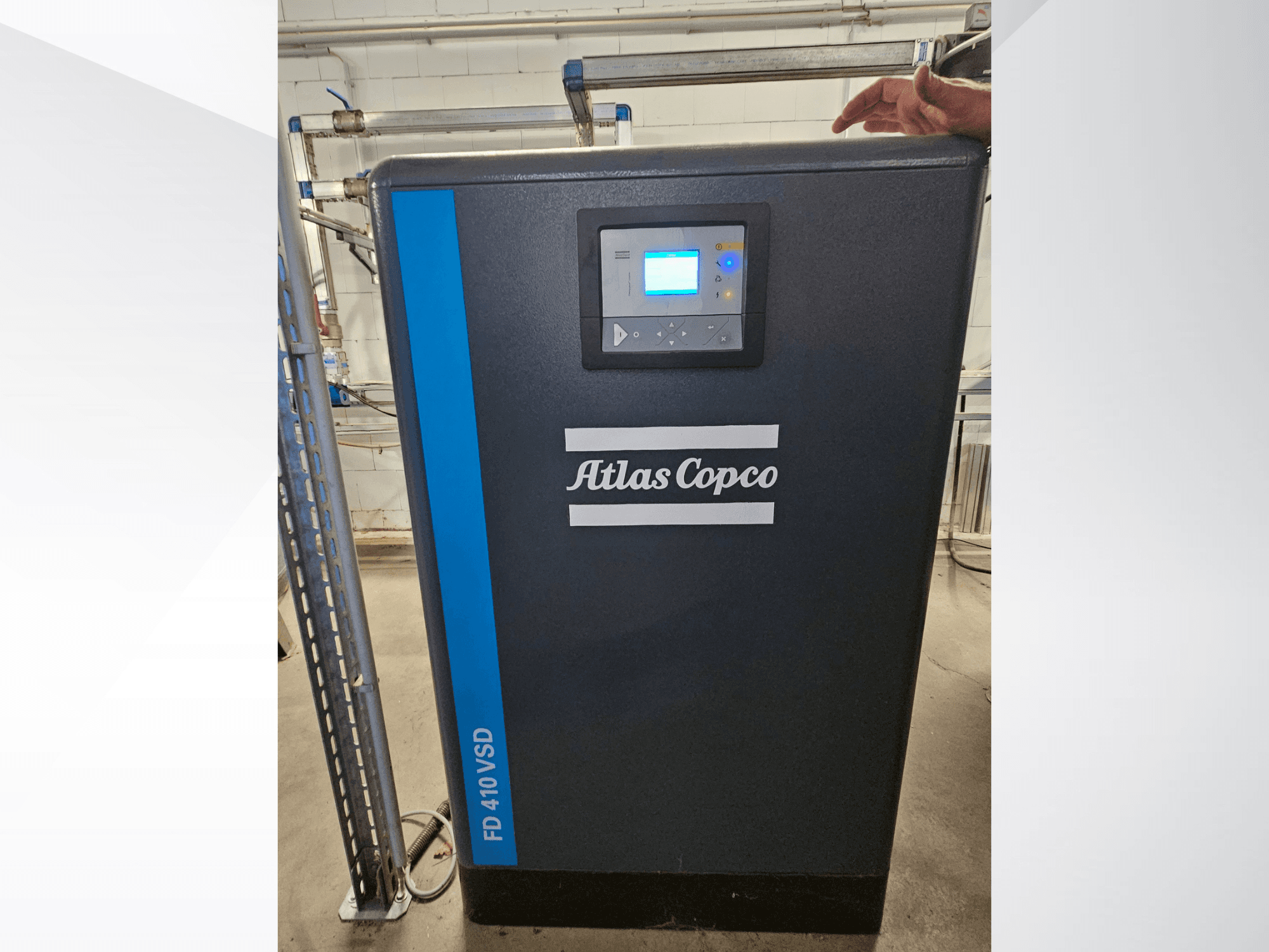 Atlas Copco GA 110 VSD+ gaisa kompresors priekšpusē ar digitālo displeju un ziliem akcentiem, kas atvieglo identifikāciju.