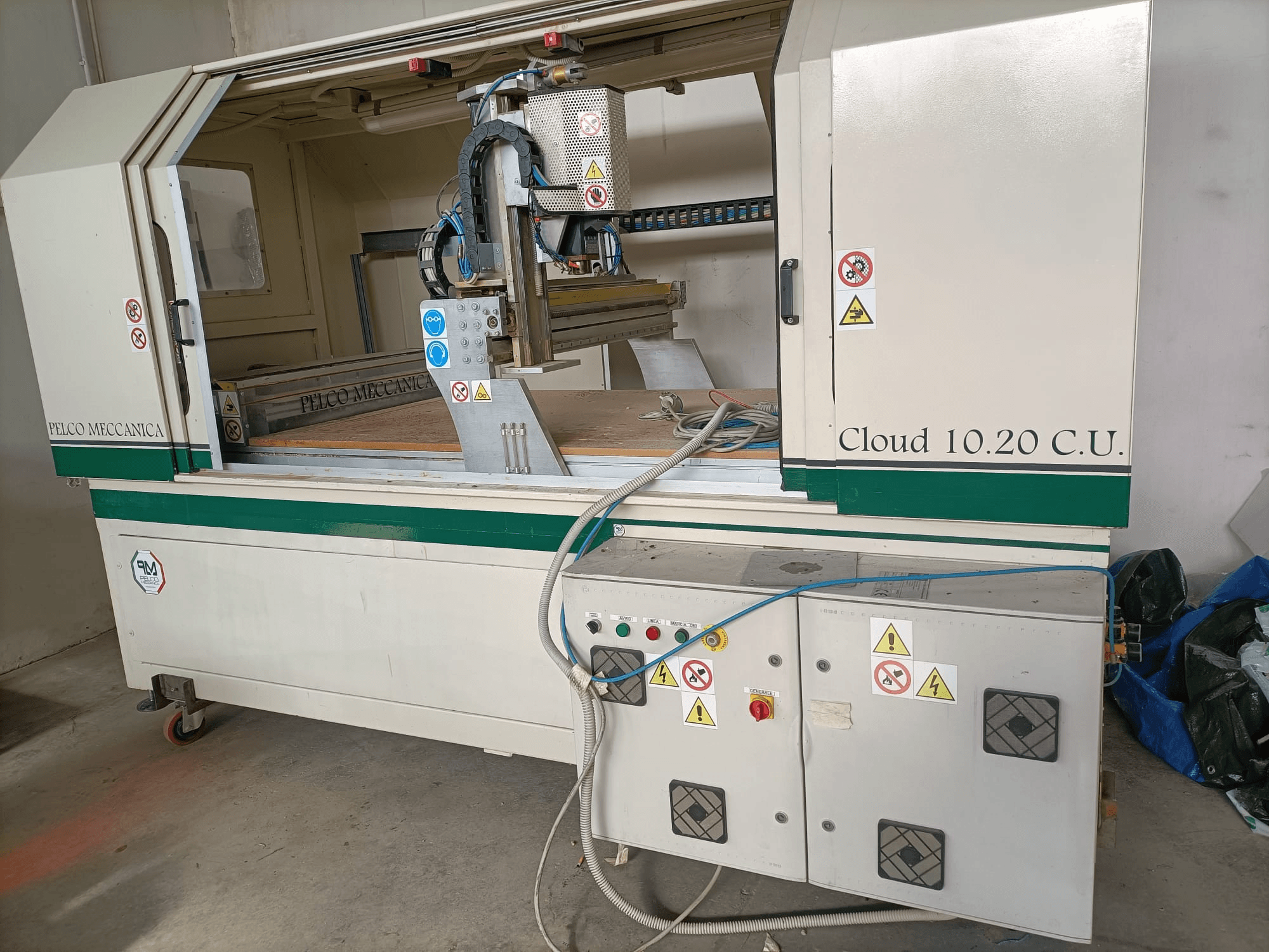 CNC frēzētājs MECCANICA CLOUD 10.20 C.U., priekšējais skats, kurā redzams vadības panelis un darba vieta, ar redzamām drošības uzlīmēm un šļūtenēm.