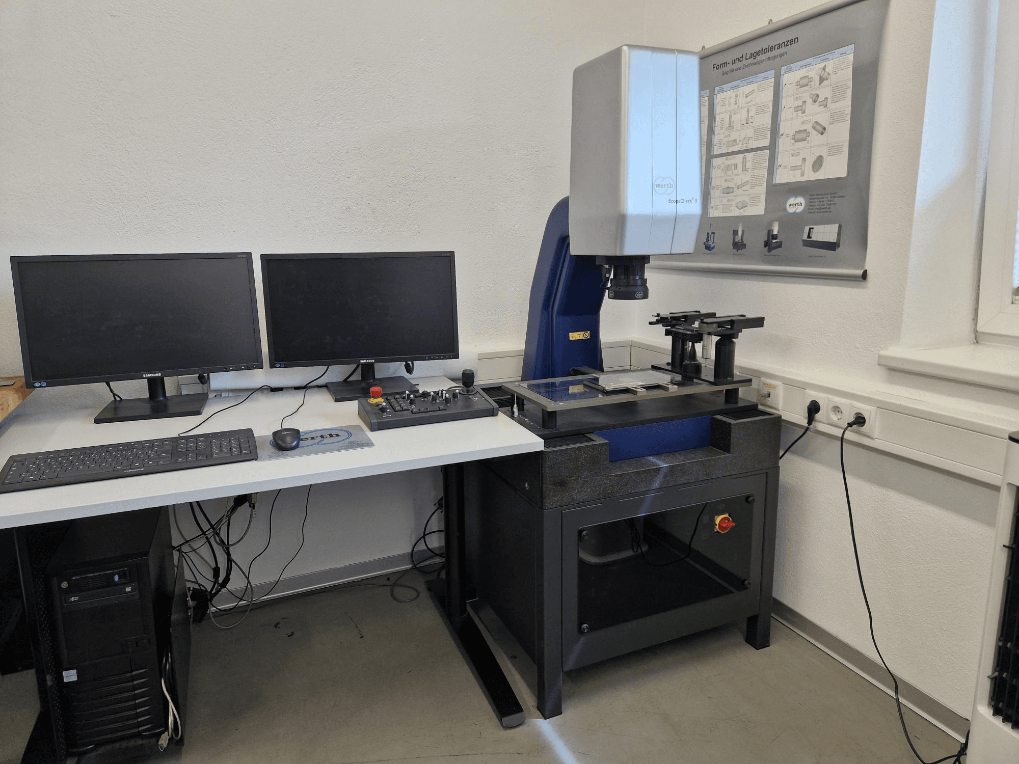Werth Scopecheck 300S CMM laboratorijā; ietver mērīšanas galdu, divus monitorus un vadības paneli.