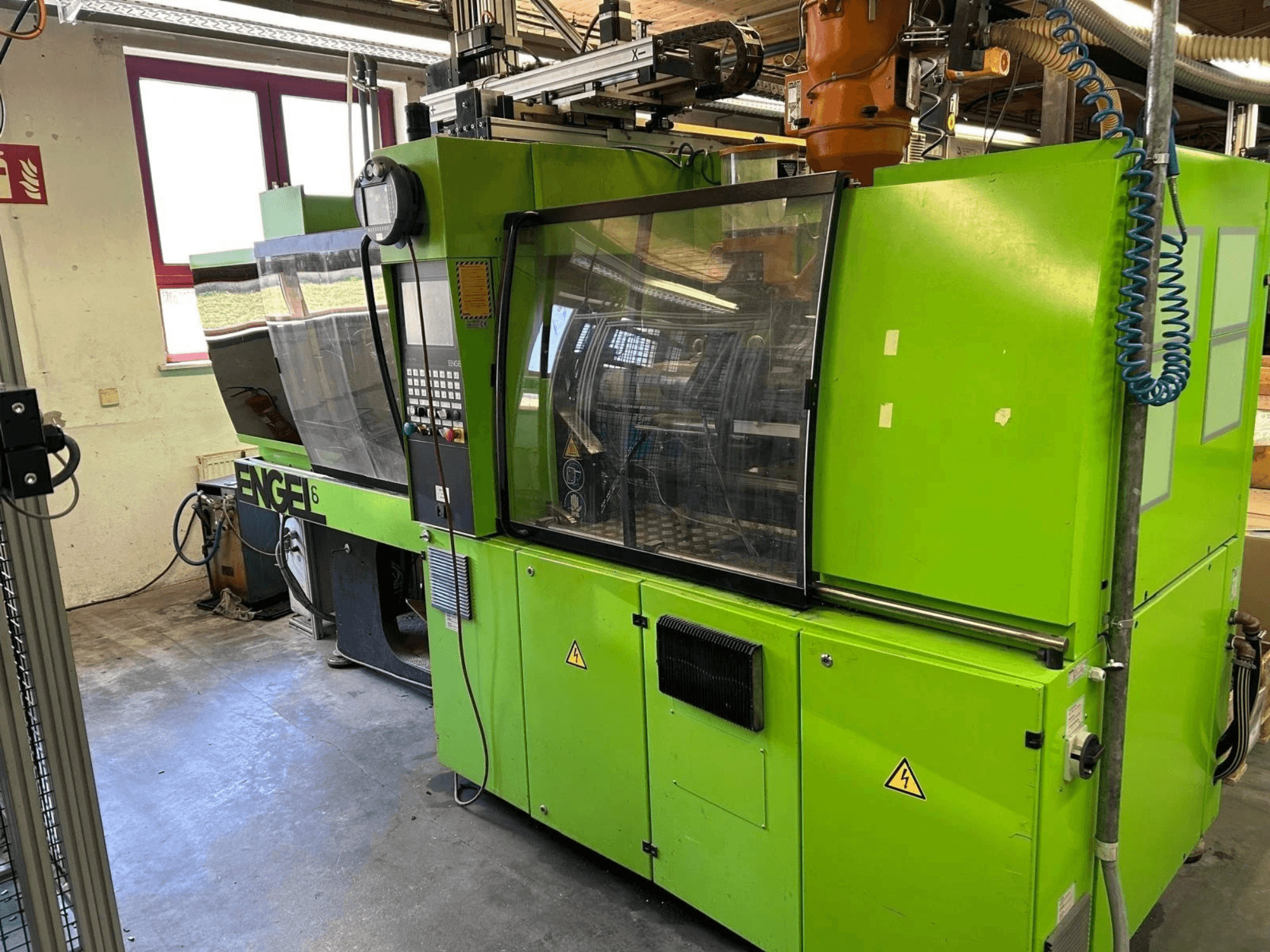 Engel VICTORY 330/80 Tech hidrauliskās injekcijas formēšanas mašīnas skats no priekšpuses, kurā redzams zaļais korpuss un vadības panelis.