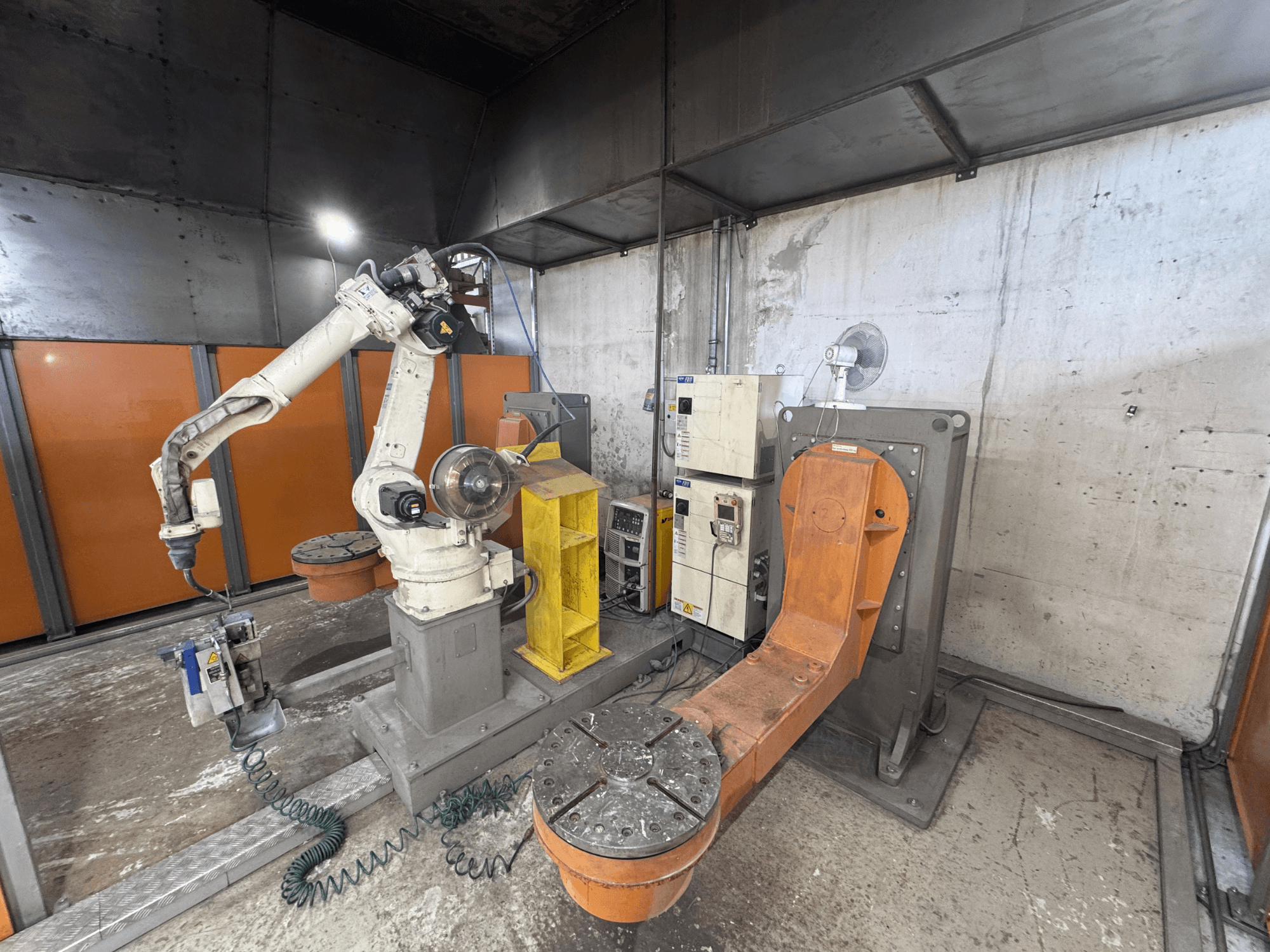 DAIHEN VARSTROJ FD-B4L 1GM/2DM robota roka rūpnieciskā vidē, skats no sāniem, redzams vadības panelis un grozāmā bāze.