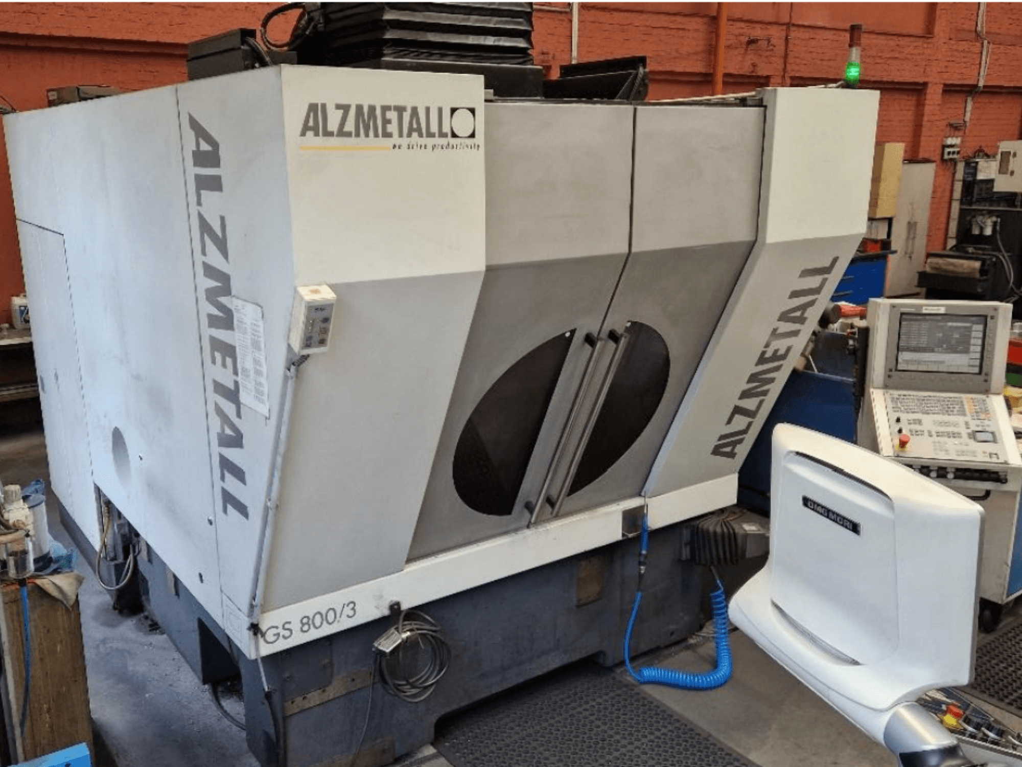 Vertikālais apstrādes centrs „Alzmetall GS 800/3“ — skats no priekšpuses, kurā redzams mašīnas korpuss un vadības panelis.