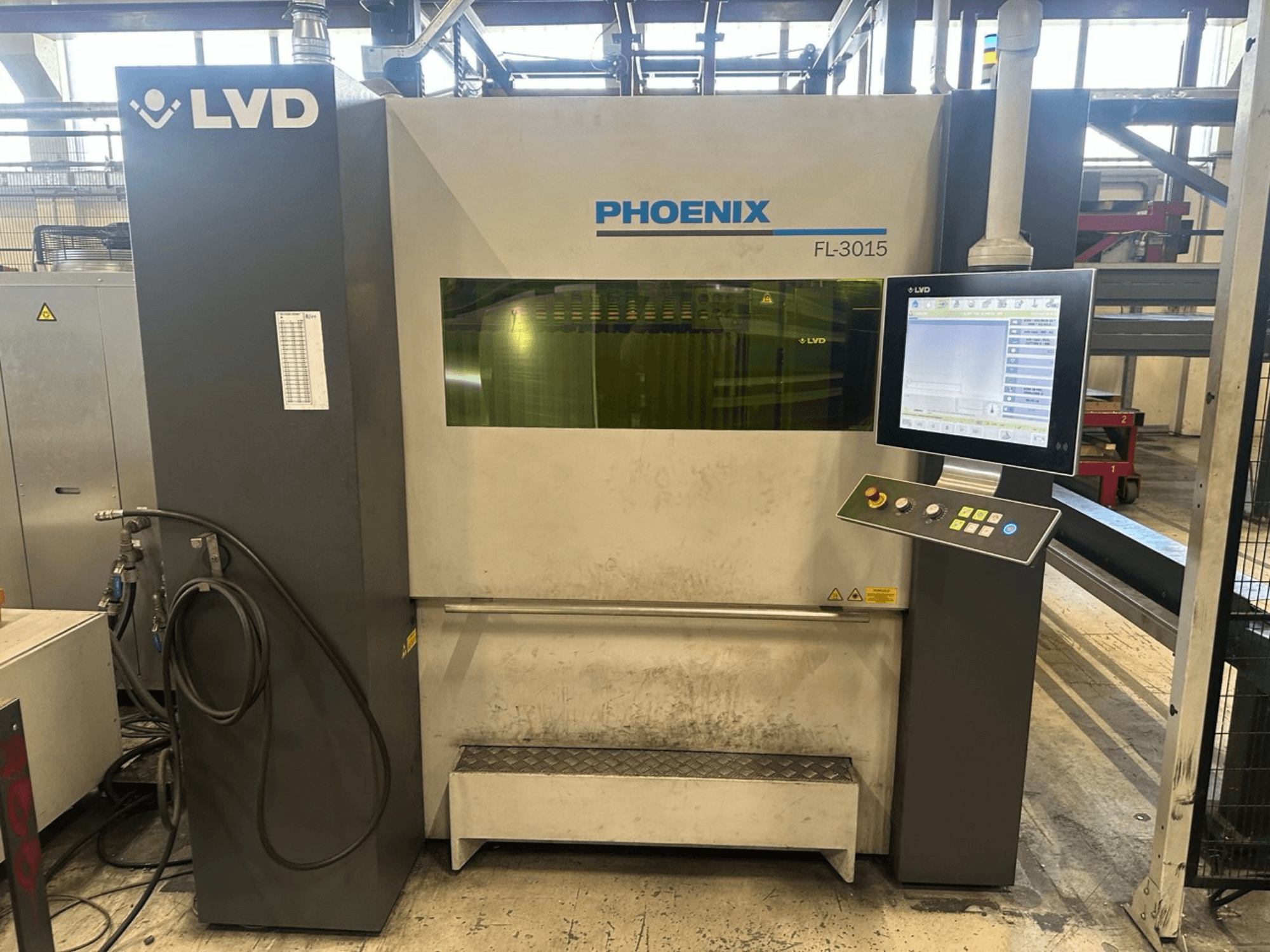 LVD Phoenix FL-3015 lāzera griešanas iekārta, skats no priekšpuses, ar digitālo vadības paneli un redzamām caurulēm.