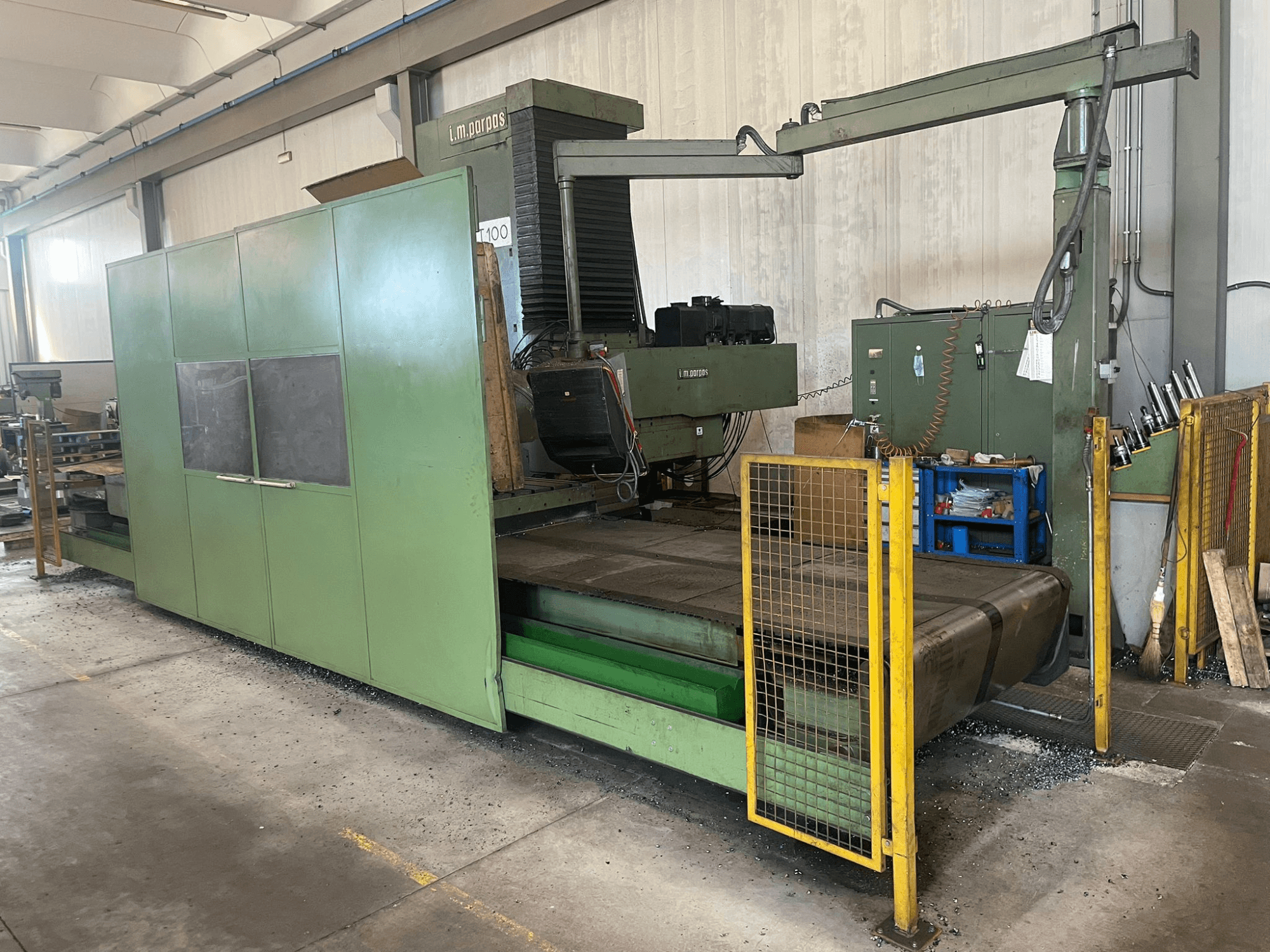 Liela zaļa rūpnieciskā frēzmašīna ar drošības barjerām, skats no priekšpuses, ar modeļa marķējumu "l.m. parpas" un redzamām vadības ierīcēm.