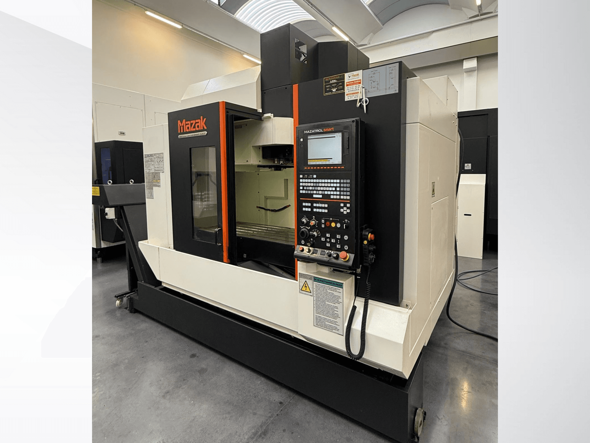 Mazak CNC darbgalds, skats no priekšpuses, ar vadības paneli un plašu darba zonu ar precīzas griešanas instrumentiem.