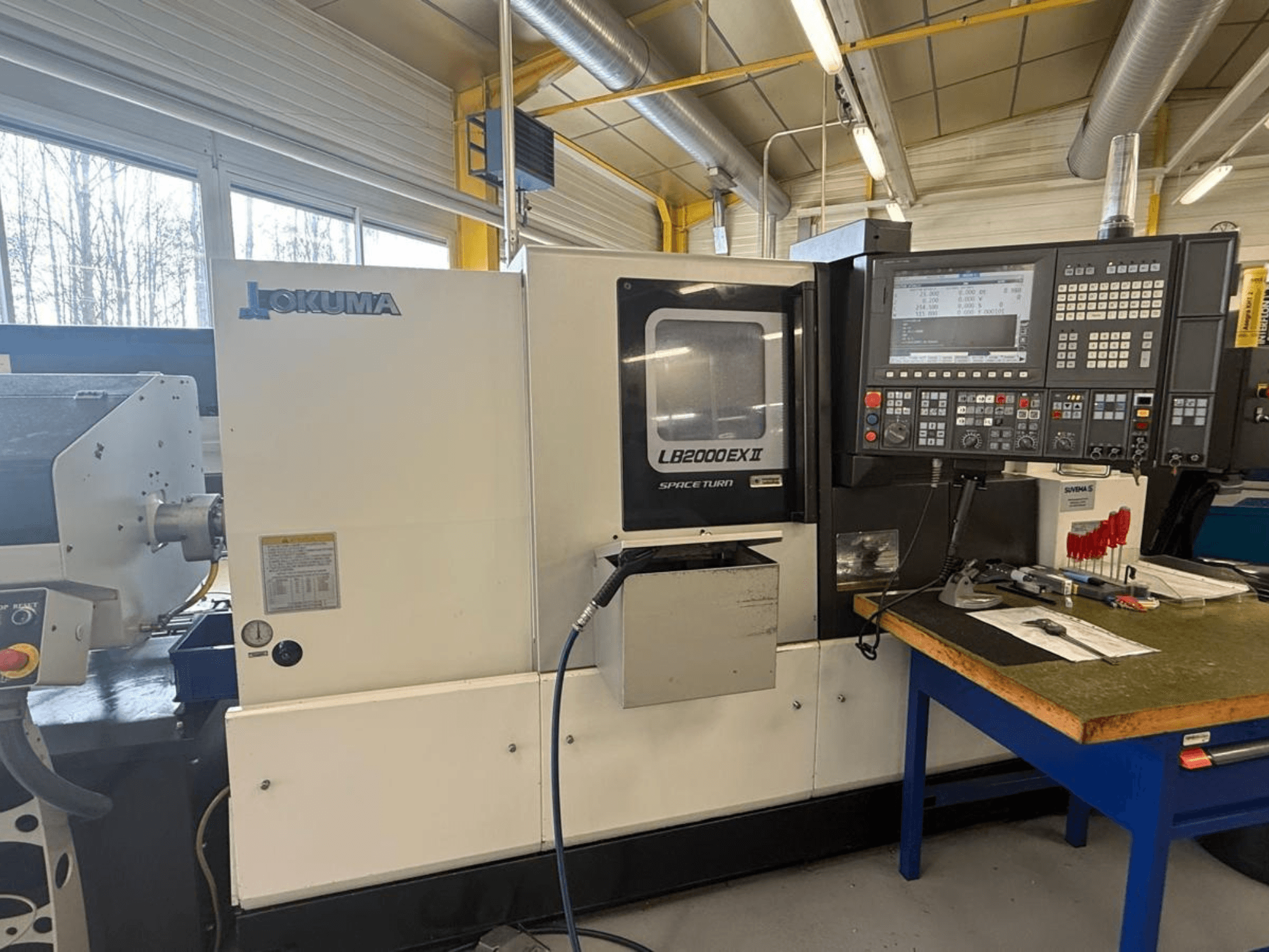 Okuma LB2000EX II horizontālās virpošanas darbgalds, skats no priekšpuses; vadības panelis, vārpstas zona un apkārtējā darba telpa.
