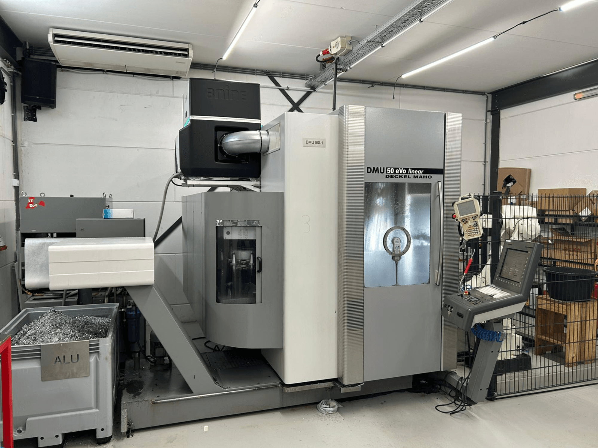 Deckel Maho DMU 50 eVo lineārā frēzmašīna, skats no priekšpuses, ar vadības paneli un skaidu tvertni.