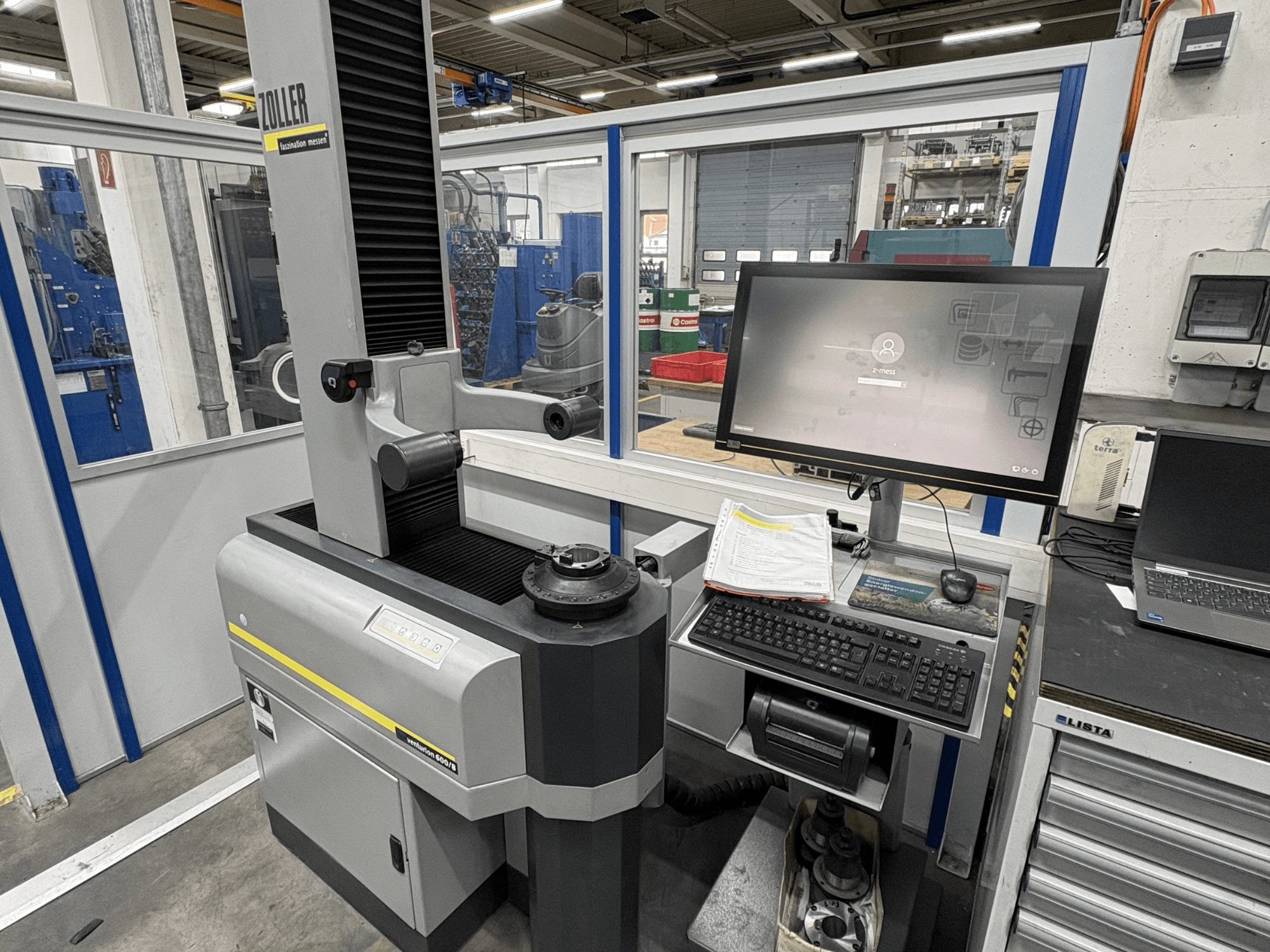 Zoller Venturion 600/8 optiskā mērīšanas iekārta darbnīcā ar monitoru, tastatūru un mērīšanas platformu sānu skatā.
