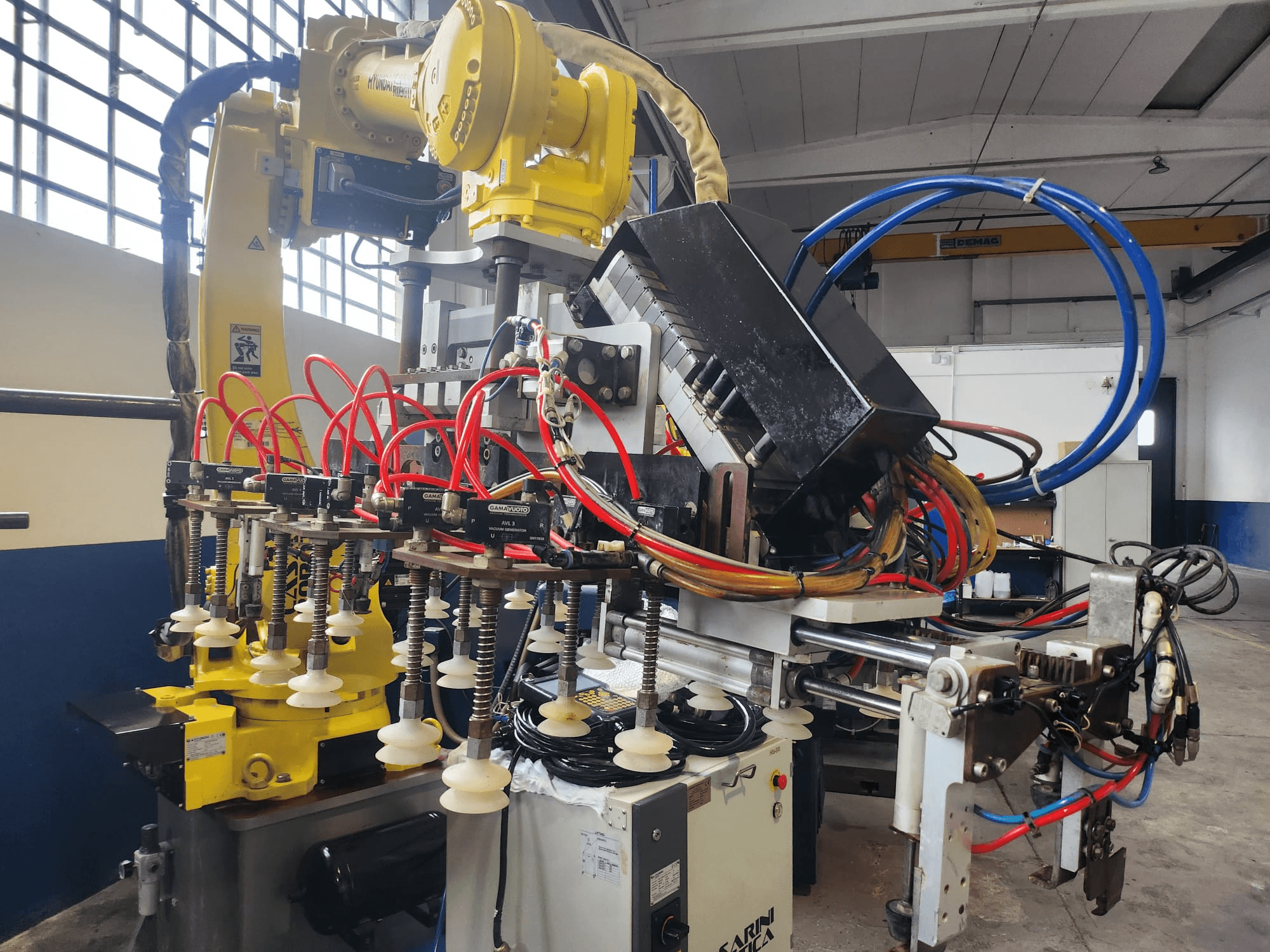 Hyundai Hi 5a-S robota roka no priekšpuses, ar vairākām šļūtenēm, vadības komponentiem un sarežģītu kabeļu izkārtojumu.