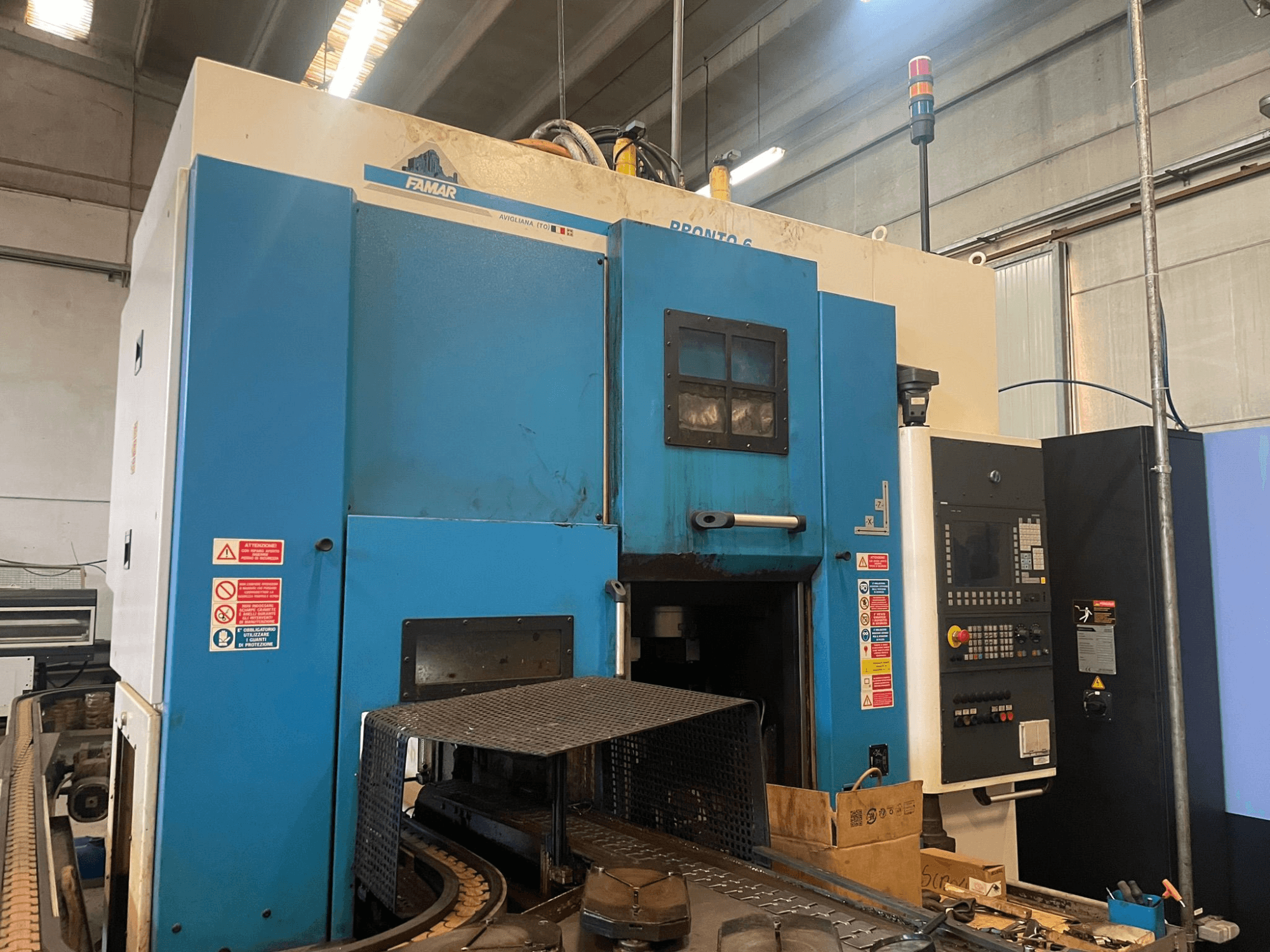 Famar Pronto 6 vertikālās virpošanas mašīna darbnīcā, skats no sāniem, redzams vadības panelis, darbības funkcijas un drošības marķējums.