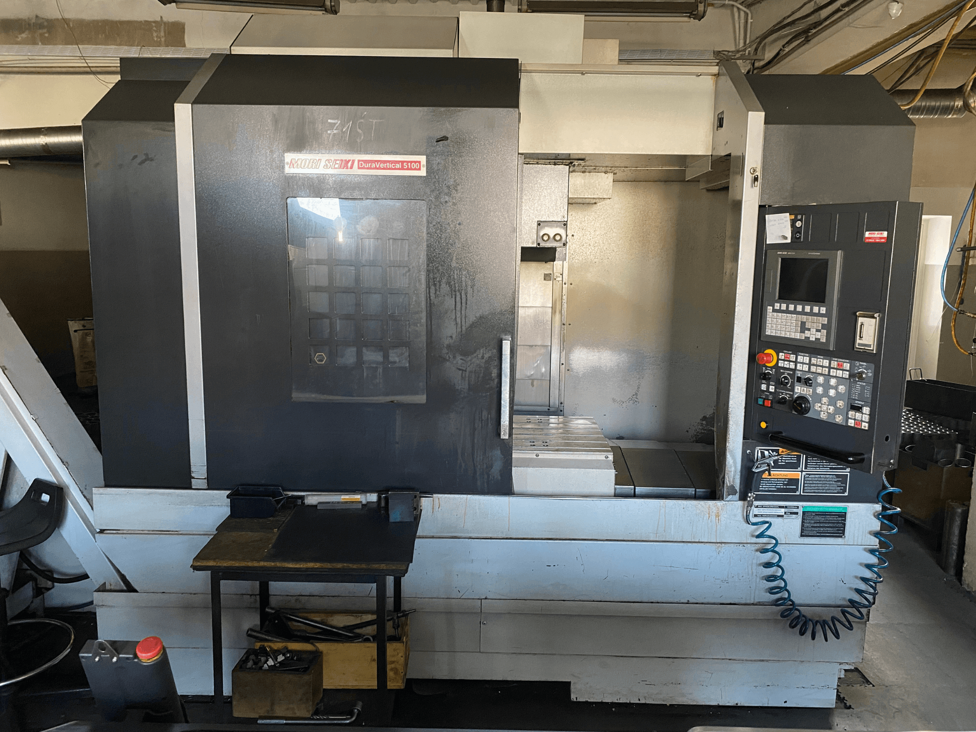 MORI SEIKI DuraVertical 5100 no priekšpuses, kur redzams vadības panelis, darba zona un mašīnas detaļas.