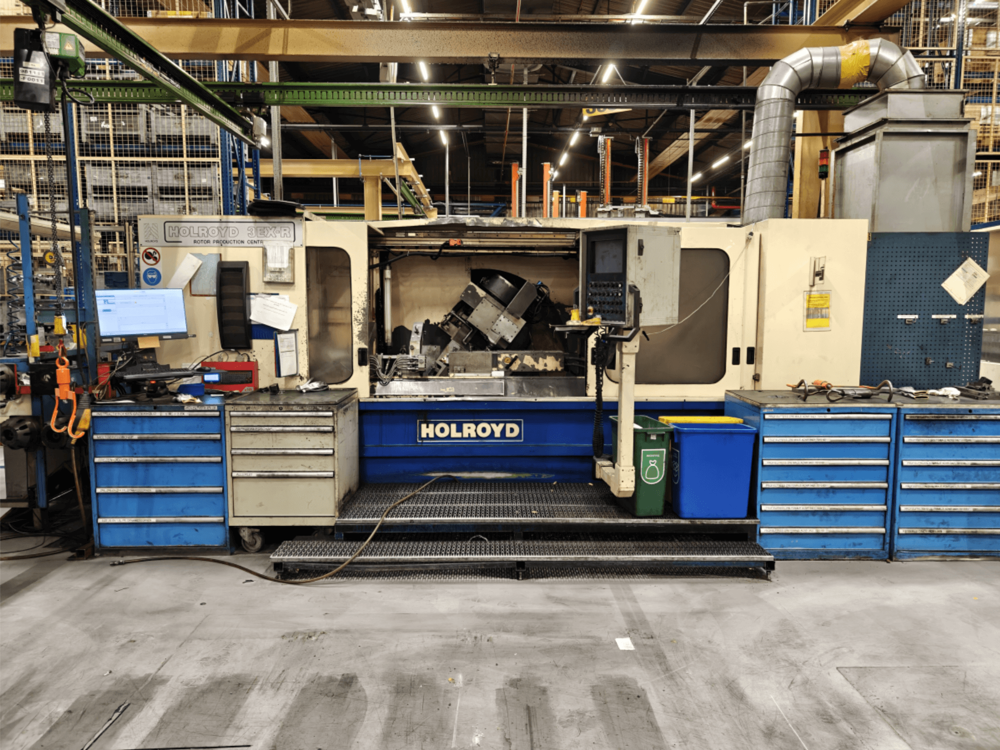 Holroyd 3EX-R darbagalds darbnīcā, skats no priekšpuses, kurā redzams vadības panelis, instrumentu glabāšanas vieta un darba zona iekšpusē.