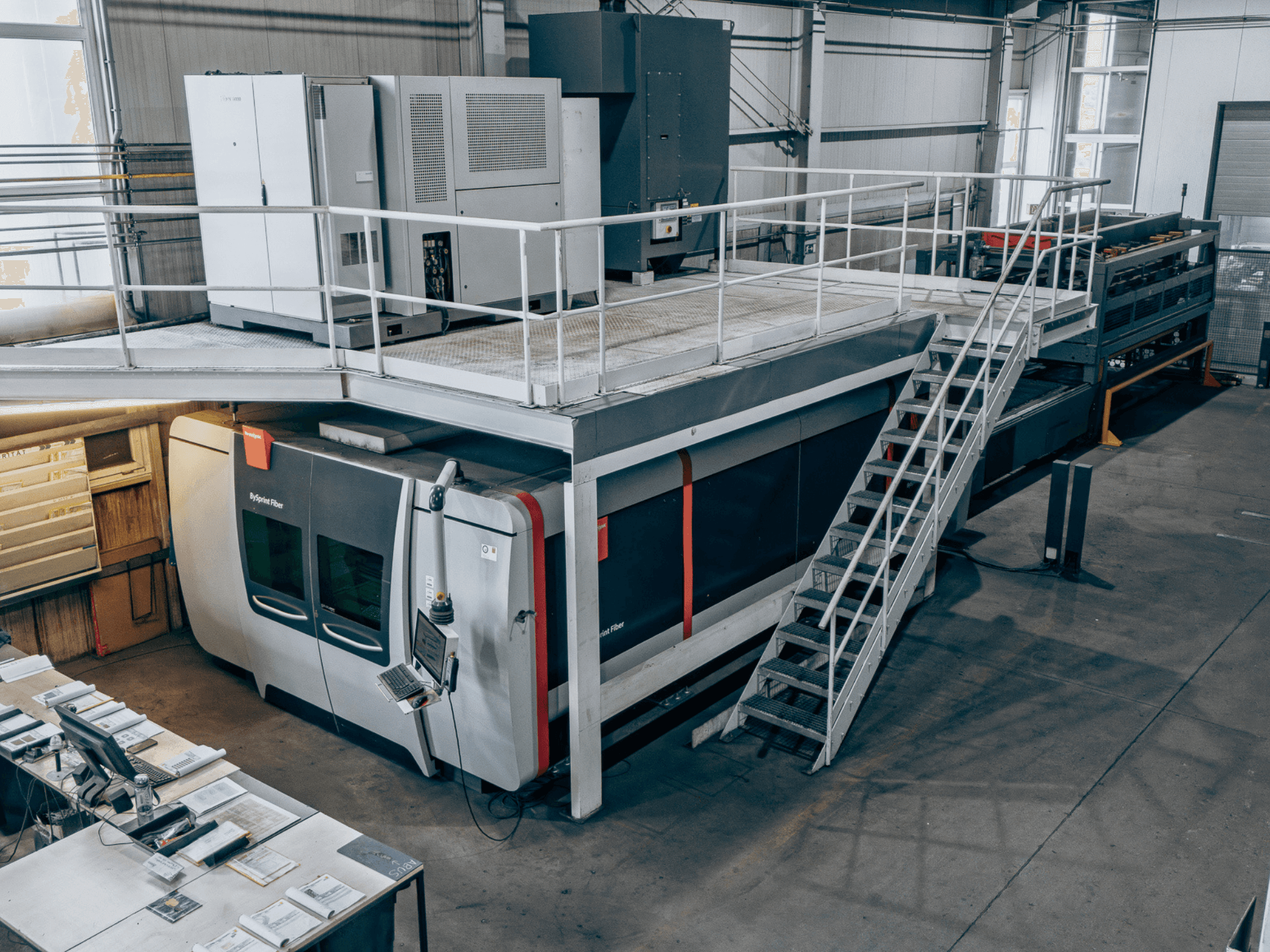 Bystronic BySprint Fiber 4020 šķiedru lāzera griešanas iekārta ar ByTransExtended 4020, skats no augšas, kurā redzams vadības panelis un kāpnes.