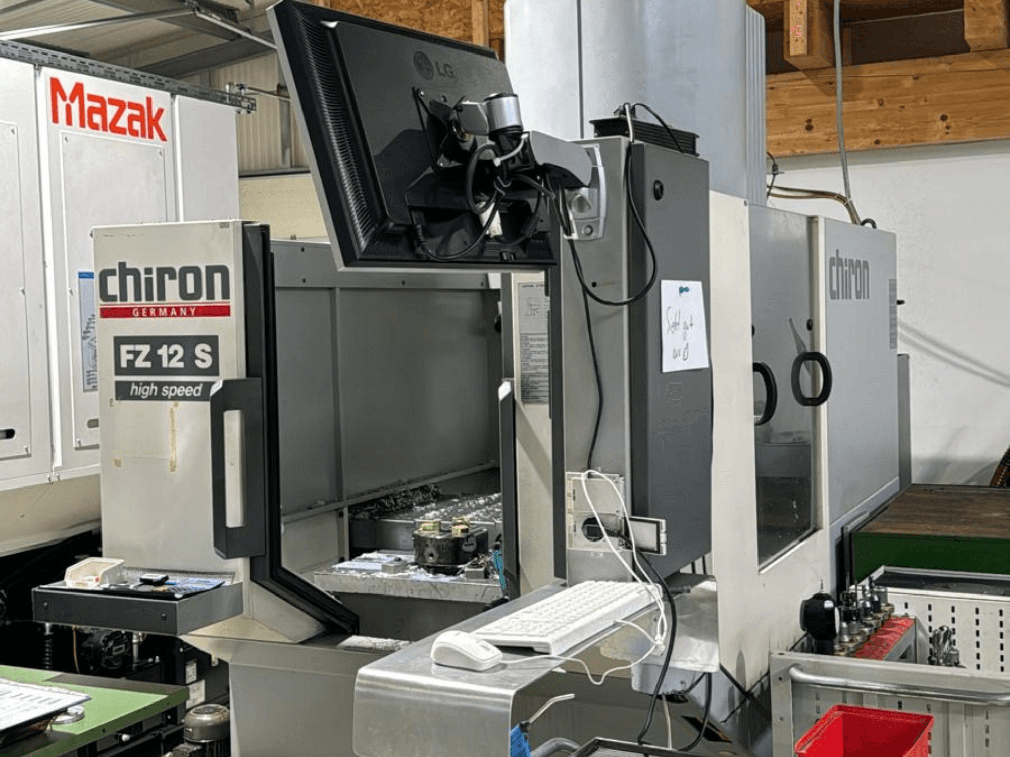 CHIRON FZ 12 S ātrgaitas apstrādes centra CHIRON FZ 12 S vertikālais skats ar vadības ekrānu un apstrādes procesa atliekām.