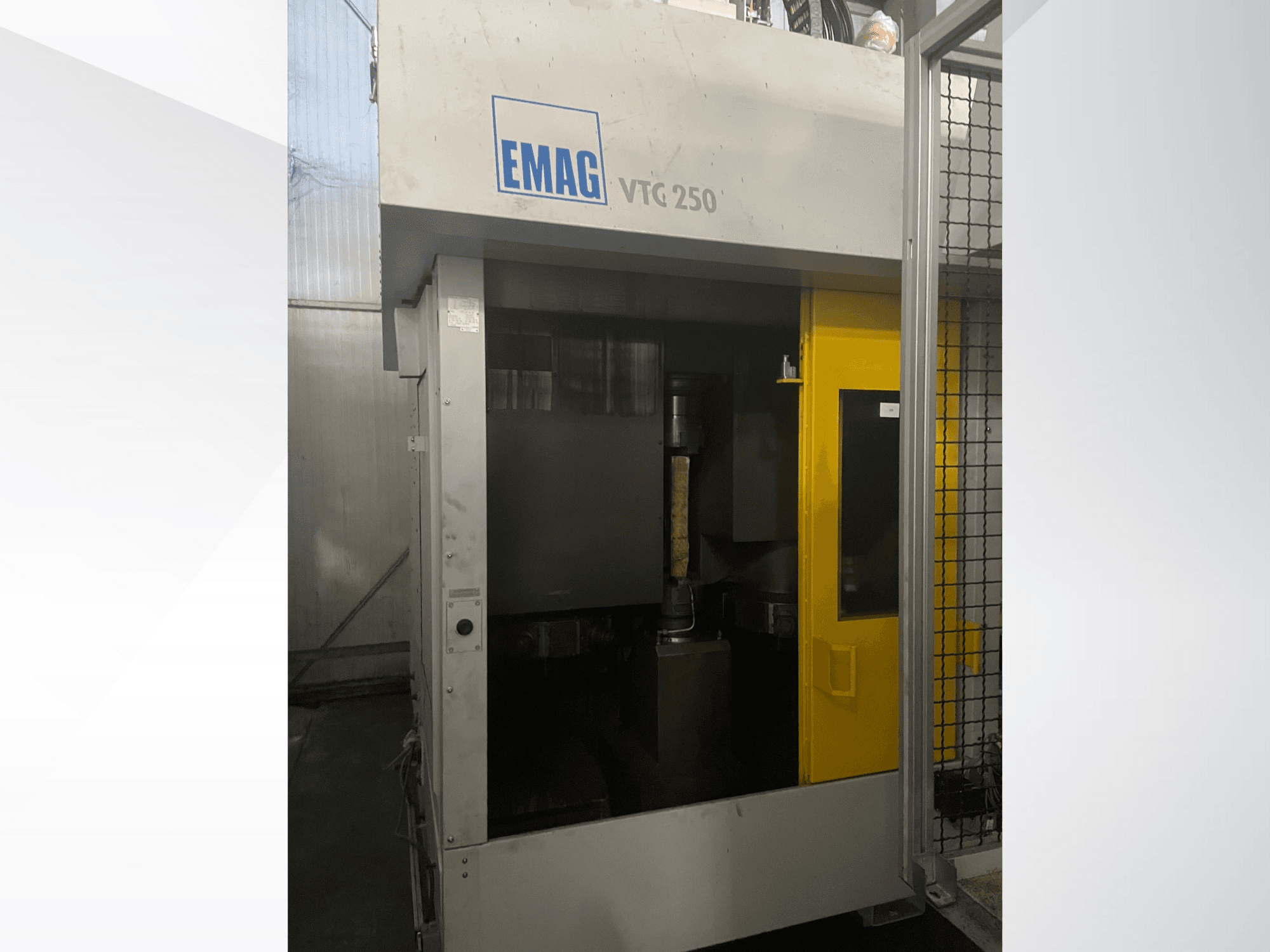 EMAG VTC 250 vertikālais apstrādes centrs priekšpusē, ar dzeltenām durvīm un redzamu griezējinstrumentu kamerā.