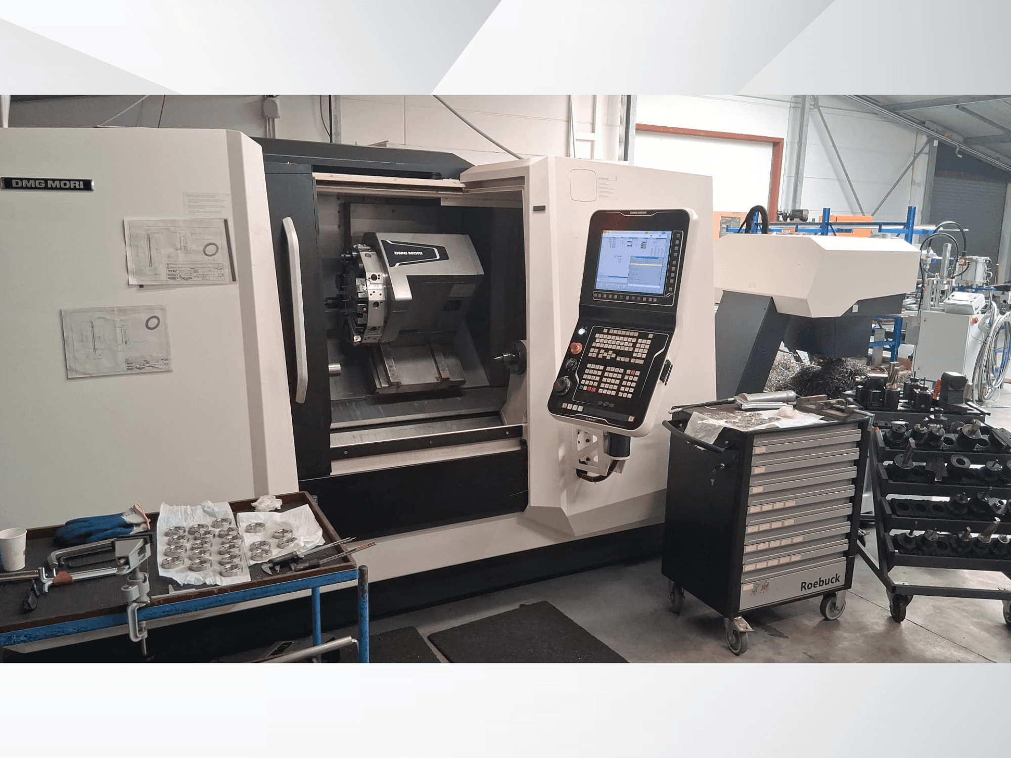 DMG MORI CLX450 horizontālās virpošanas iekārta no priekšpuses, ar vadības paneli, darba zonu, instrumentiem un metāla detaļām.