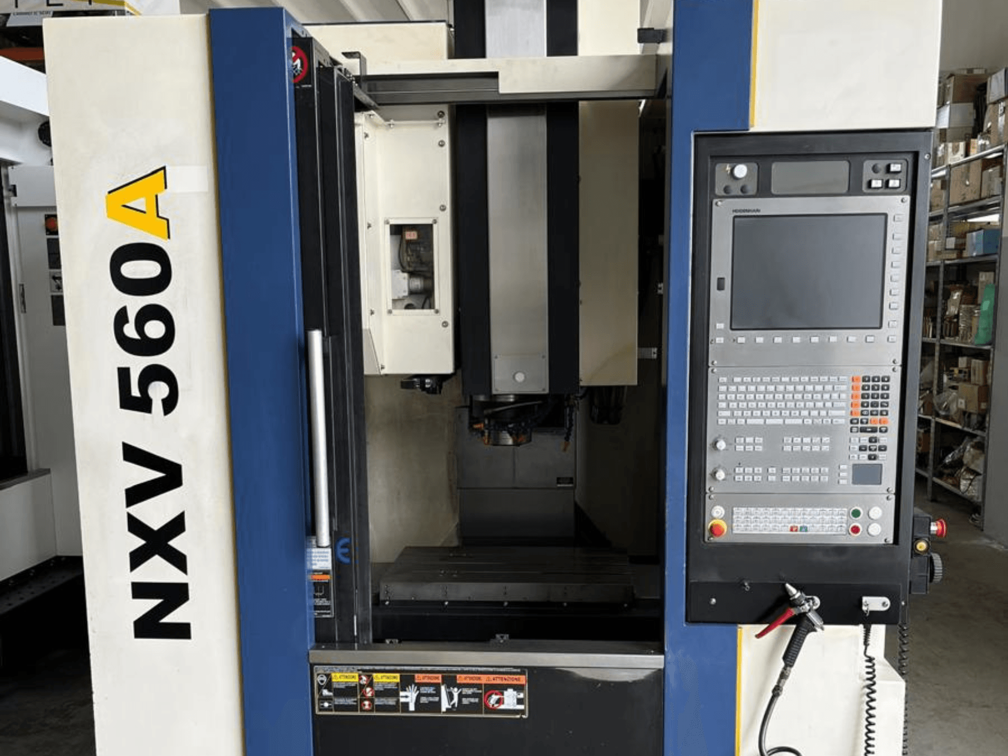 NXV 560A CNC darbagalds, skatīts no priekšpuses, ar vadības paneli ar pogām un digitālo displeju.