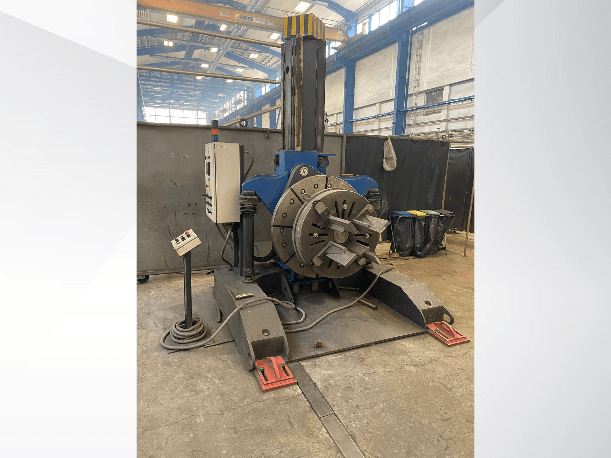 Zilas rūpnieciskās virpas ar apaļu rotējošu galvu un vadības paneli, skats no sāniem, darbnīcā.