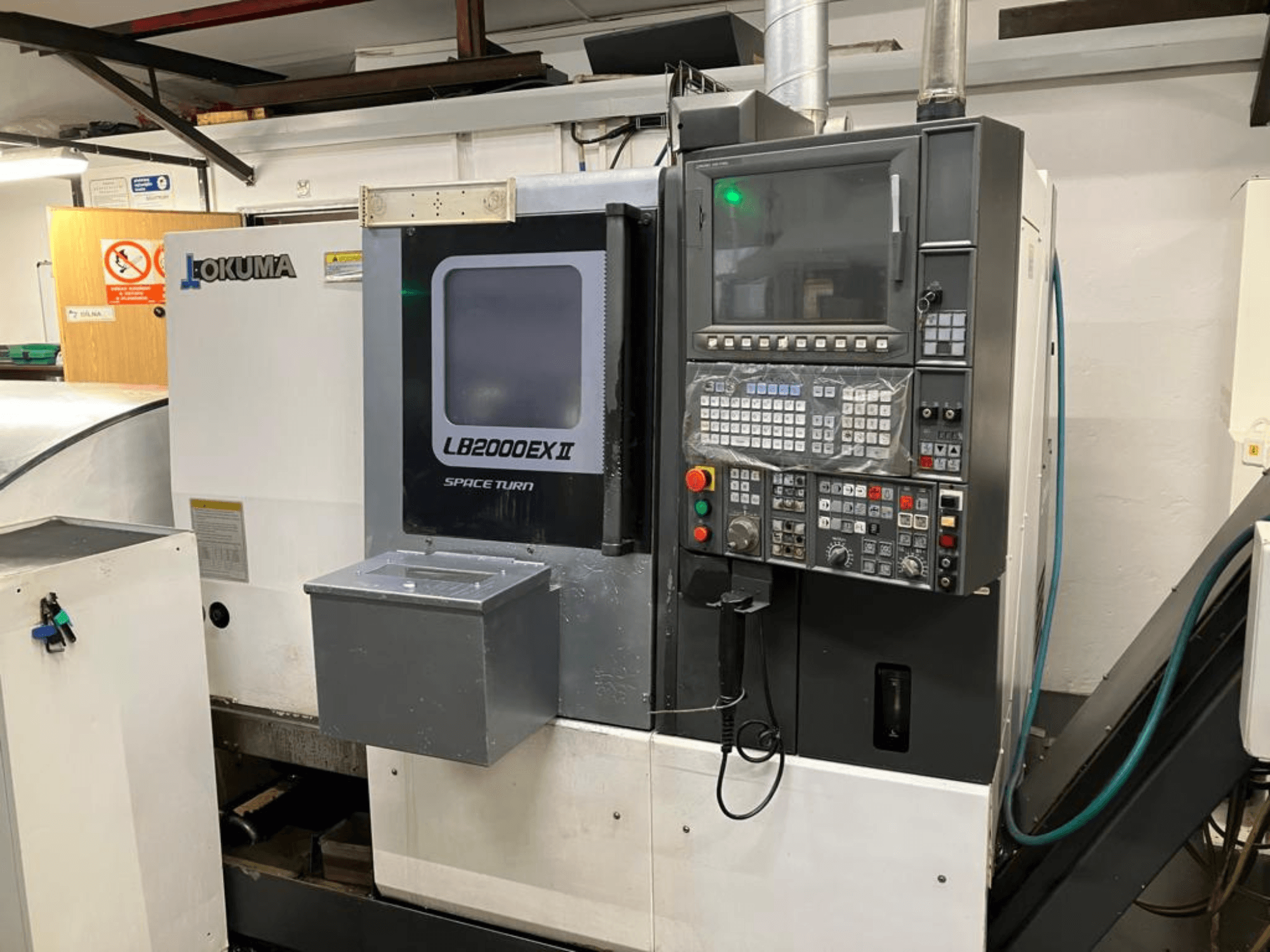 Okuma LB2000EXII MC horizontālās virpošanas iekārta, priekšējais skats, kurā redzams vadības panelis un darbības funkcijas.