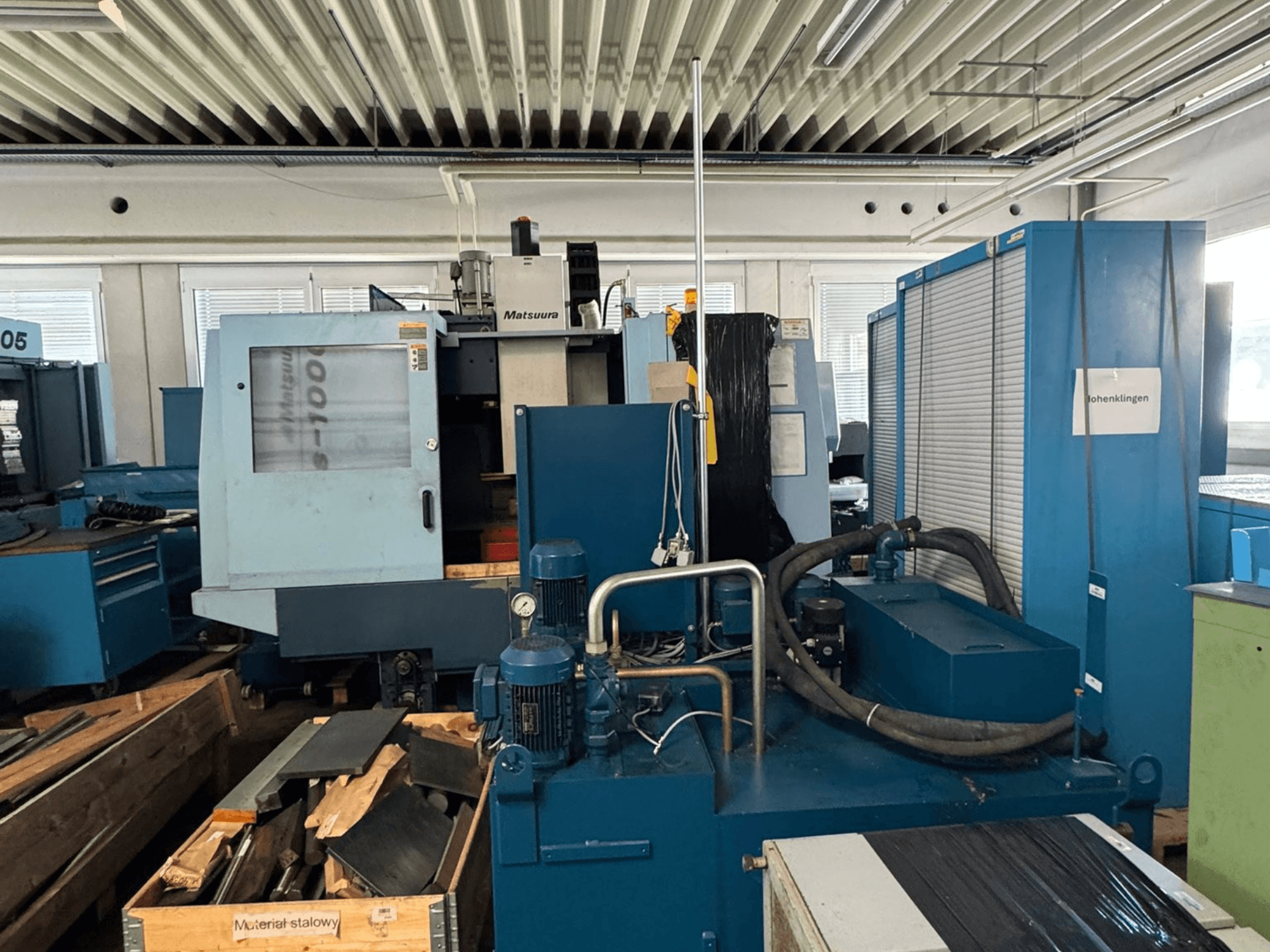 Matsuura Vplus 1000/40 vertikālā apstrādes centra skats no priekšpuses, kurā redzamas vadības ierīces, motori un apkārtējā darbnīcas vide.