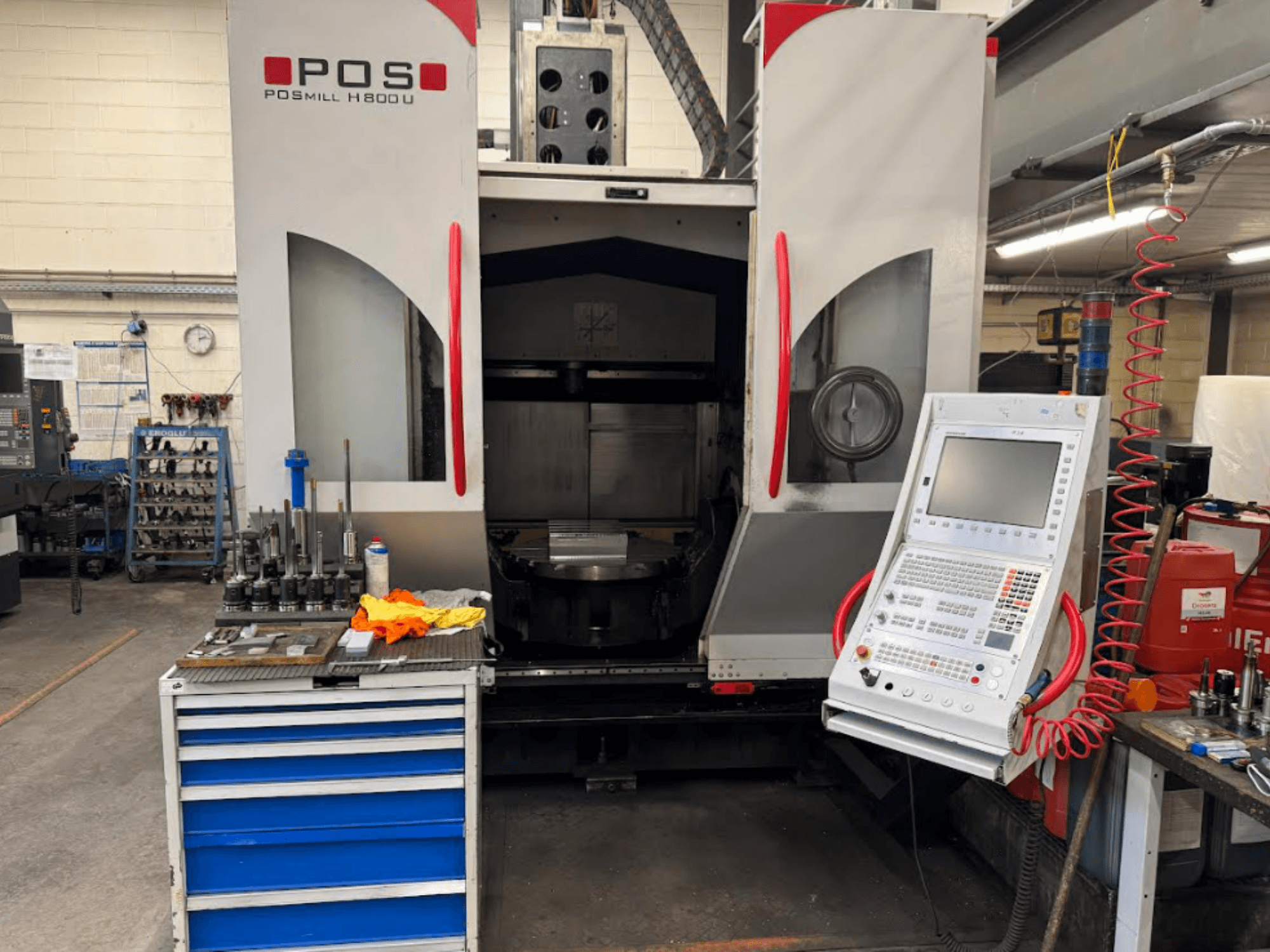 POSMILL H800 U CNC darbgalds no priekšpuses, kurā redzams vadības panelis un darba zona ar instrumentiem un iekārtām.