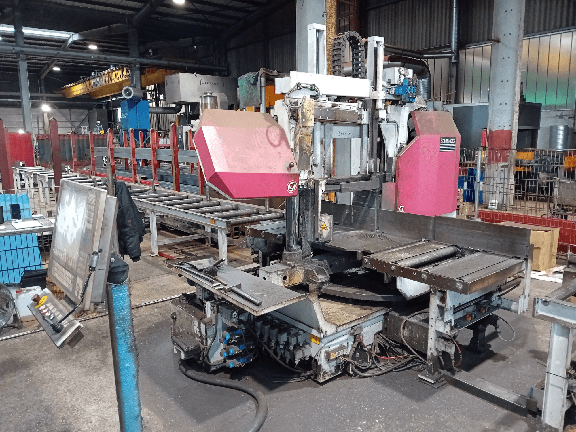 Behringer lentzāģis rūpnīcā, skats no priekšpuses, ar lielu griešanas asmeni un vadības paneli ar pogām.